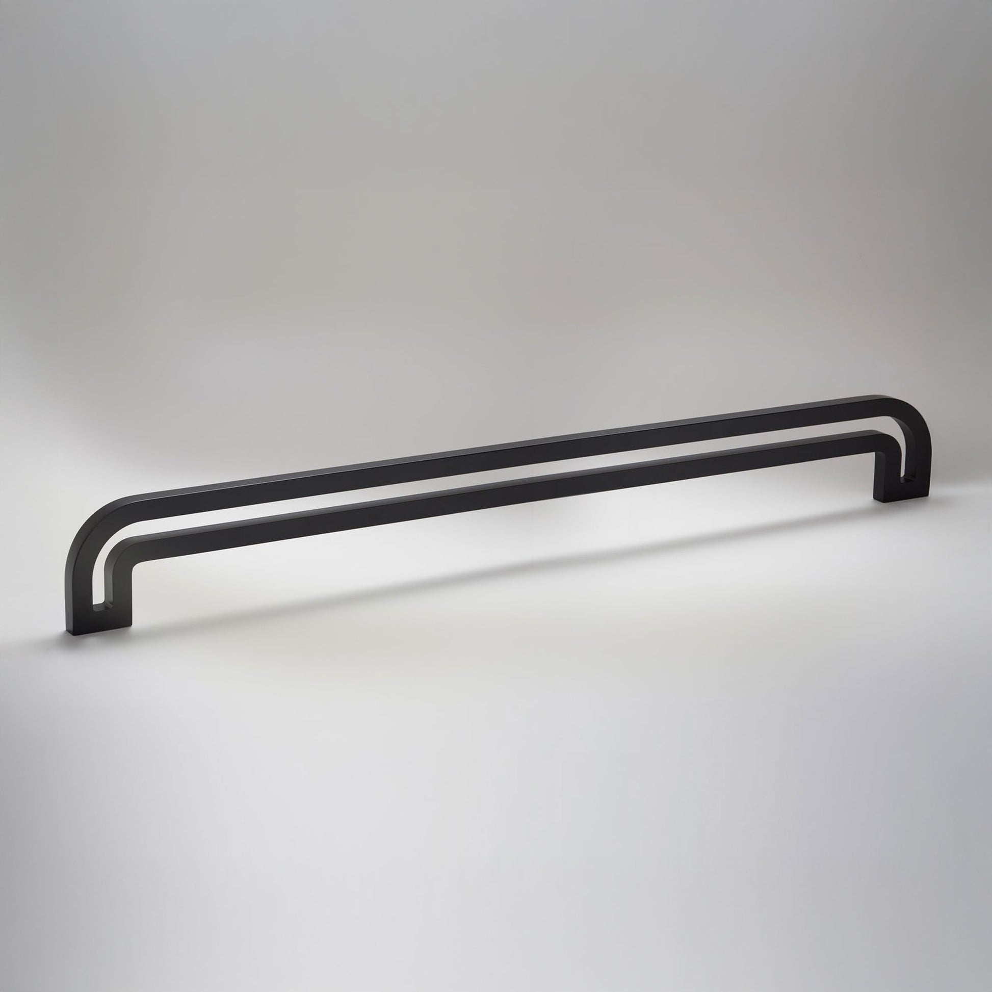 Arch shaped linear cabinet pull with cut our internal area on a grey background