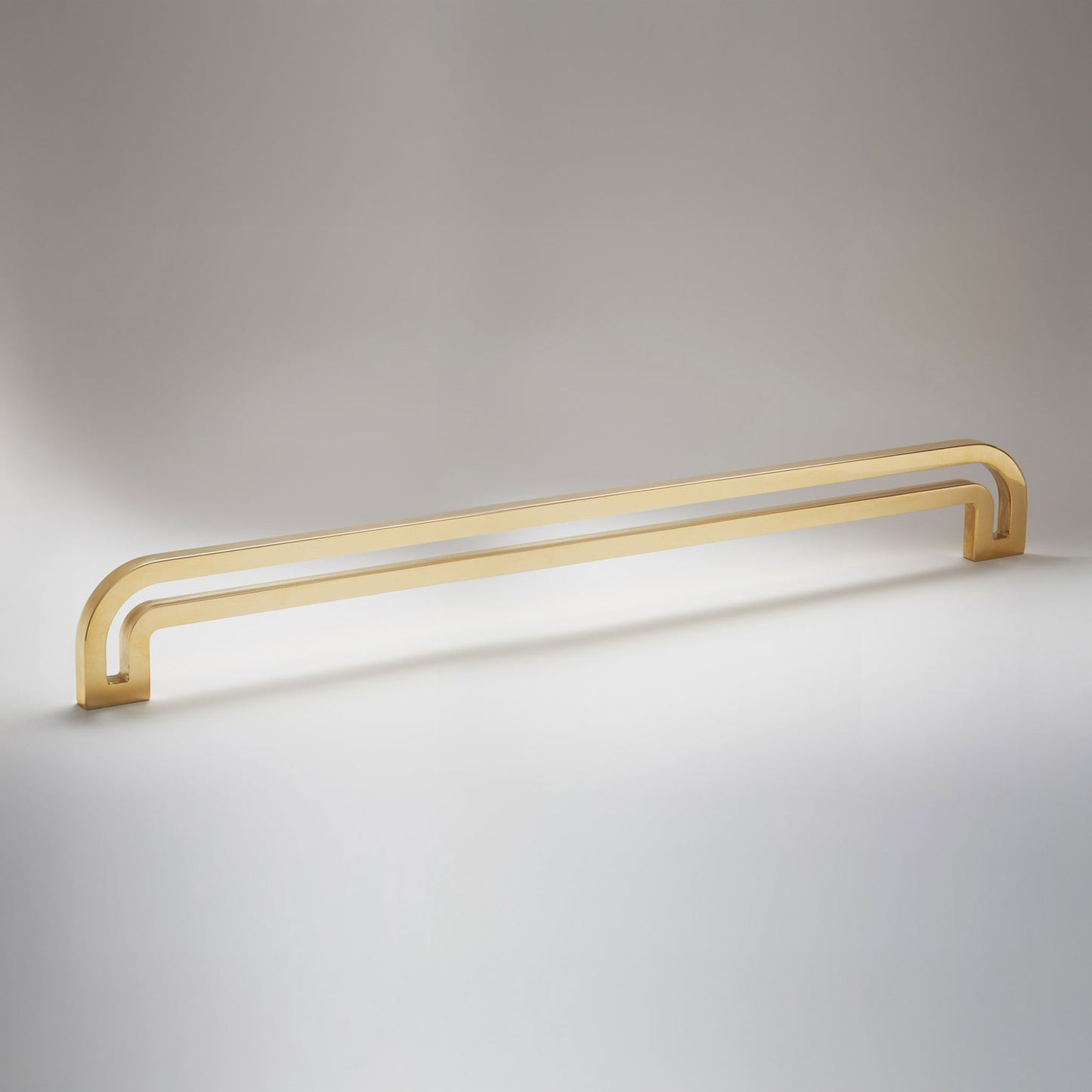 Arch shaped linear cabinet pull with cut our internal area on a grey background