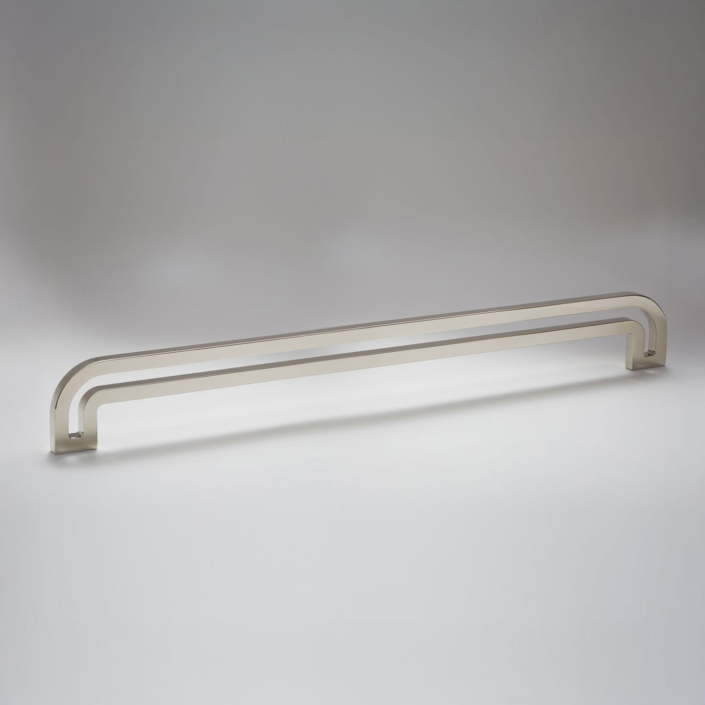 Arch shaped linear cabinet pull with cut our internal area on a grey background