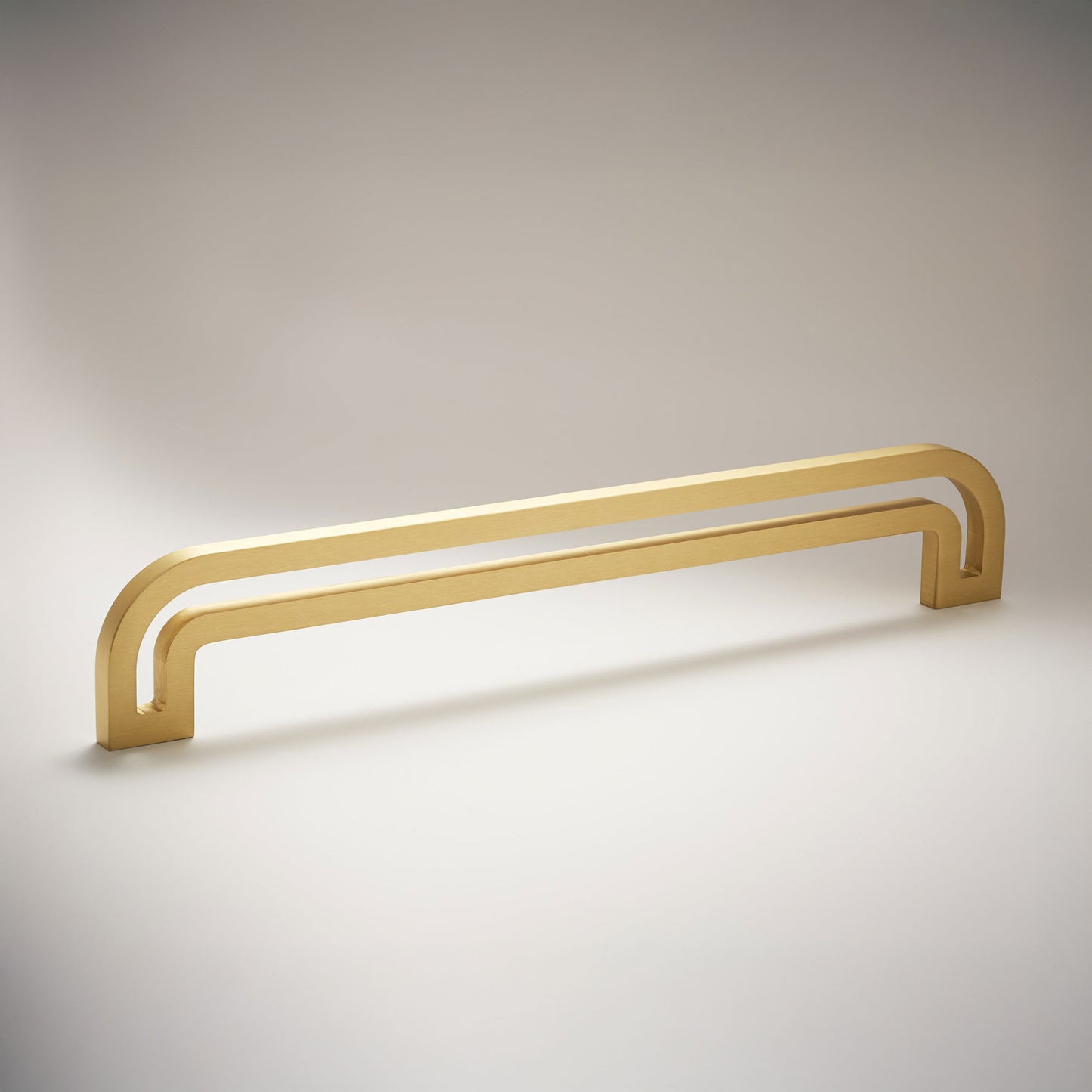 Arch shaped linear cabinet pull with cut our internal area on a grey background