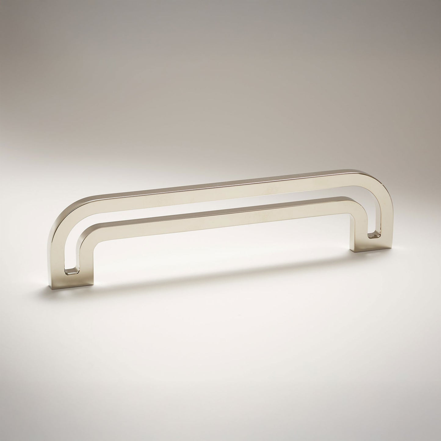 Arch shaped linear cabinet pull with cut our internal area on a grey background