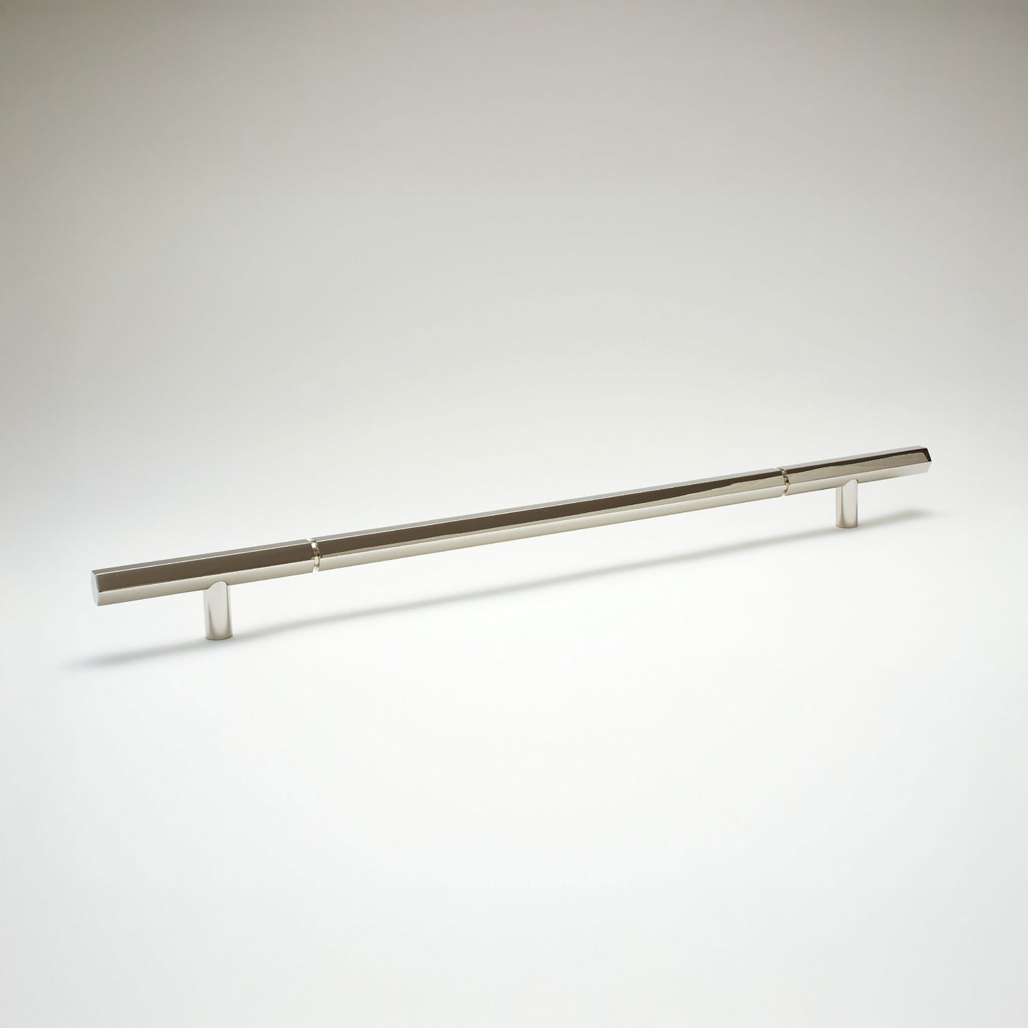 A modern hexagonal cabinet handle in polished nickel, featuring an extra long horizontal bar supported by two short cylindrical posts, shown on a light gray background.