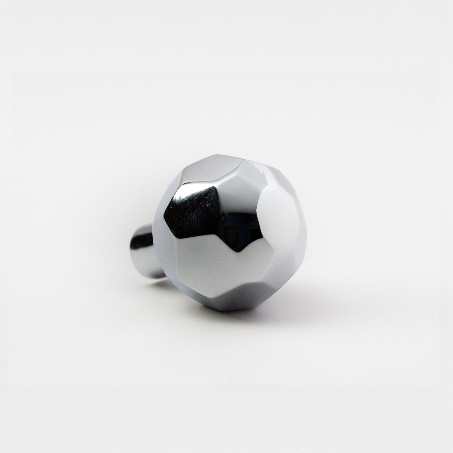 A modern hexagonal cabinet knob in polished chrome, with one short cylindrical post, shown on a light gray background.
