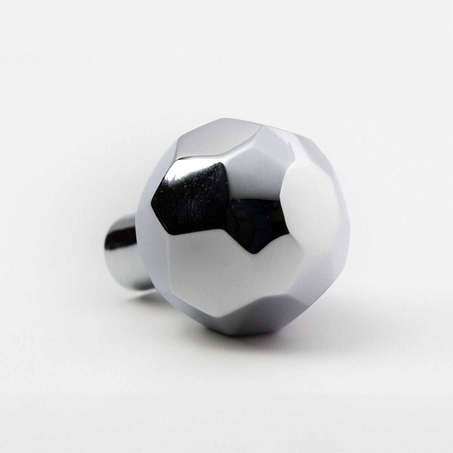 A metallic polished nickel ball-shaped cabinet knob with a faceted design and a cylindrical mounting stem, shown on a clean white background.