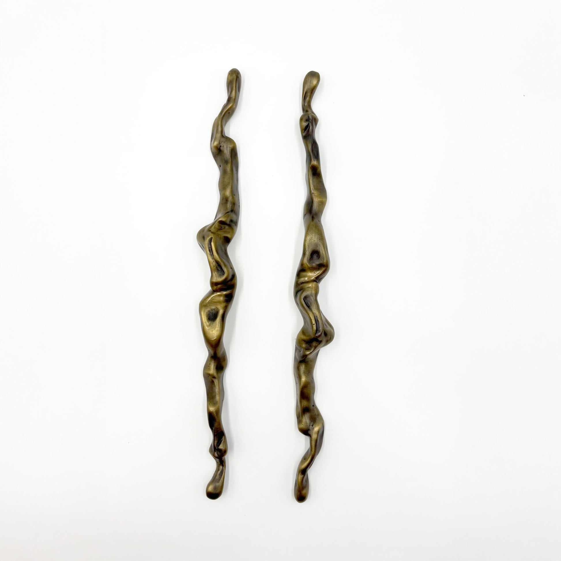 Two abstract, wavy metal cabinet handles with a distressed bronze finish, displayed vertically on a plain white background.