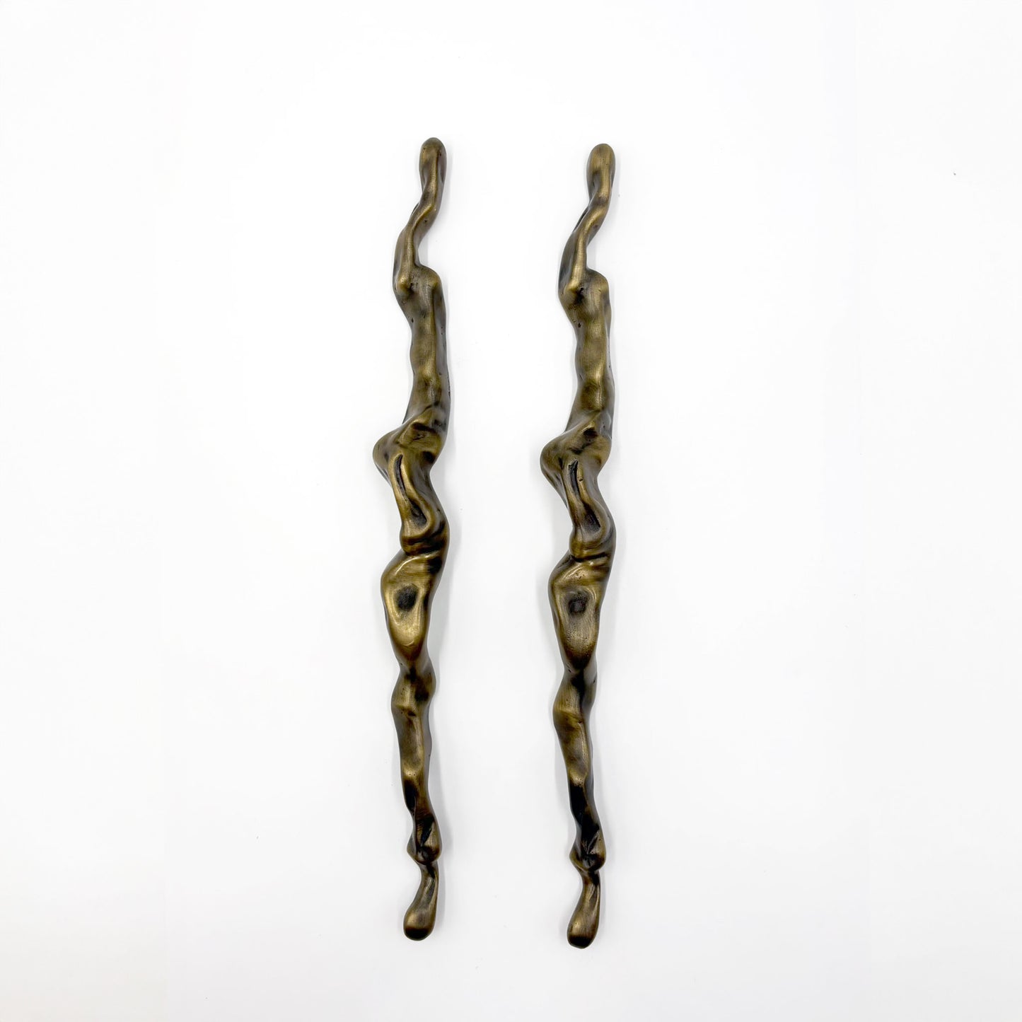 Two abstract, wavy metal cabinet handles with a distressed bronze finish, displayed vertically on a plain white background.