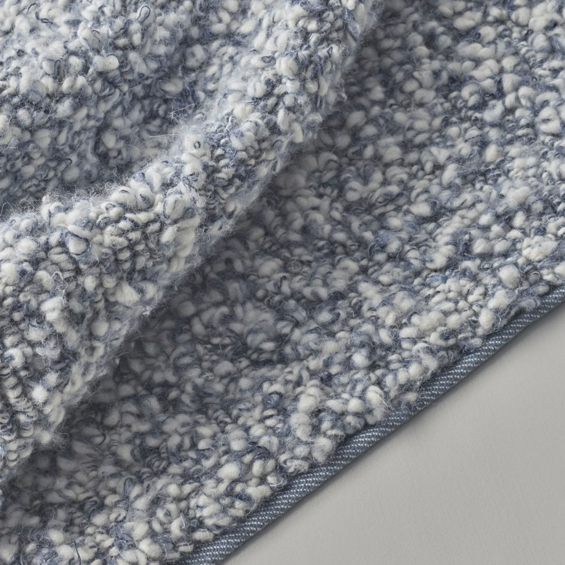 close up of Aria rug style in smoke blue and cream colored twisted textured heavy boucle weave