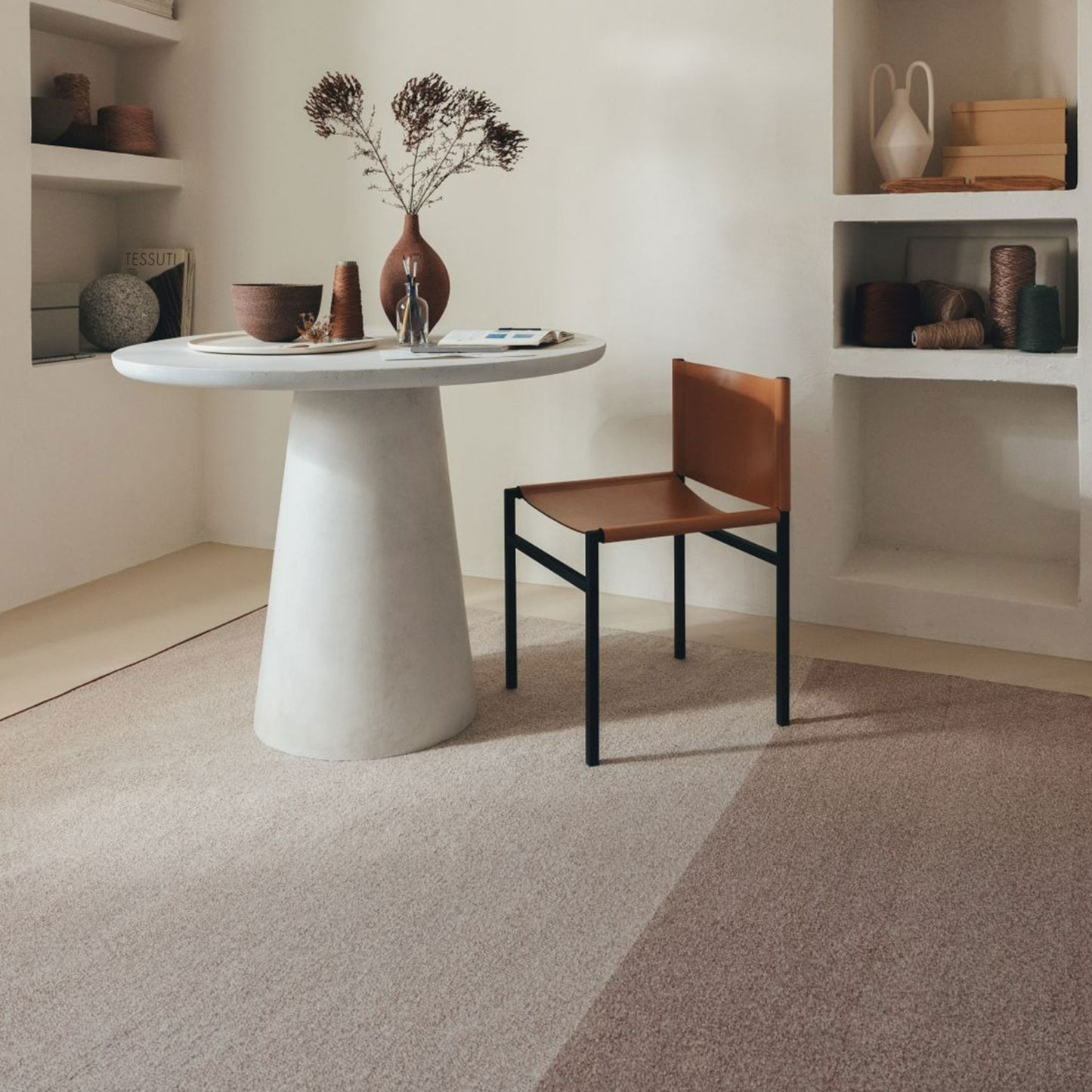 Pura rug style in pale terra cotta and buff colored twisted flat weave with a marble side table