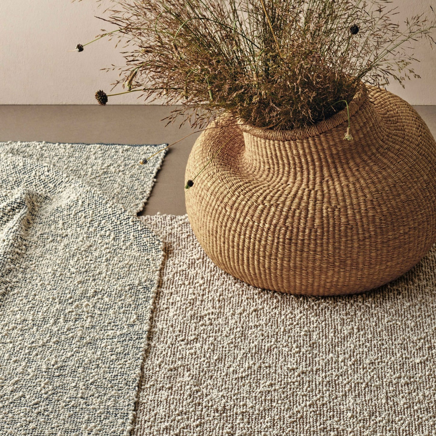 Sanenu rug styles in cream, taupe and grey colored textured boucle weave in a room with a natural basket