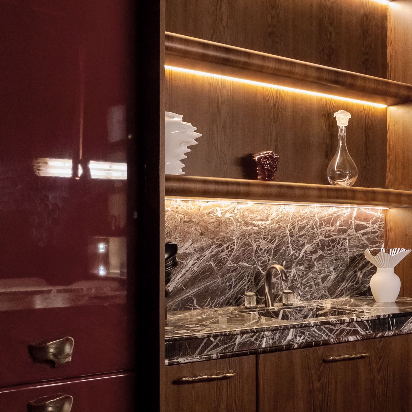 Installation view of a wooden cabinet with a organic-patterned handle and brass finish.