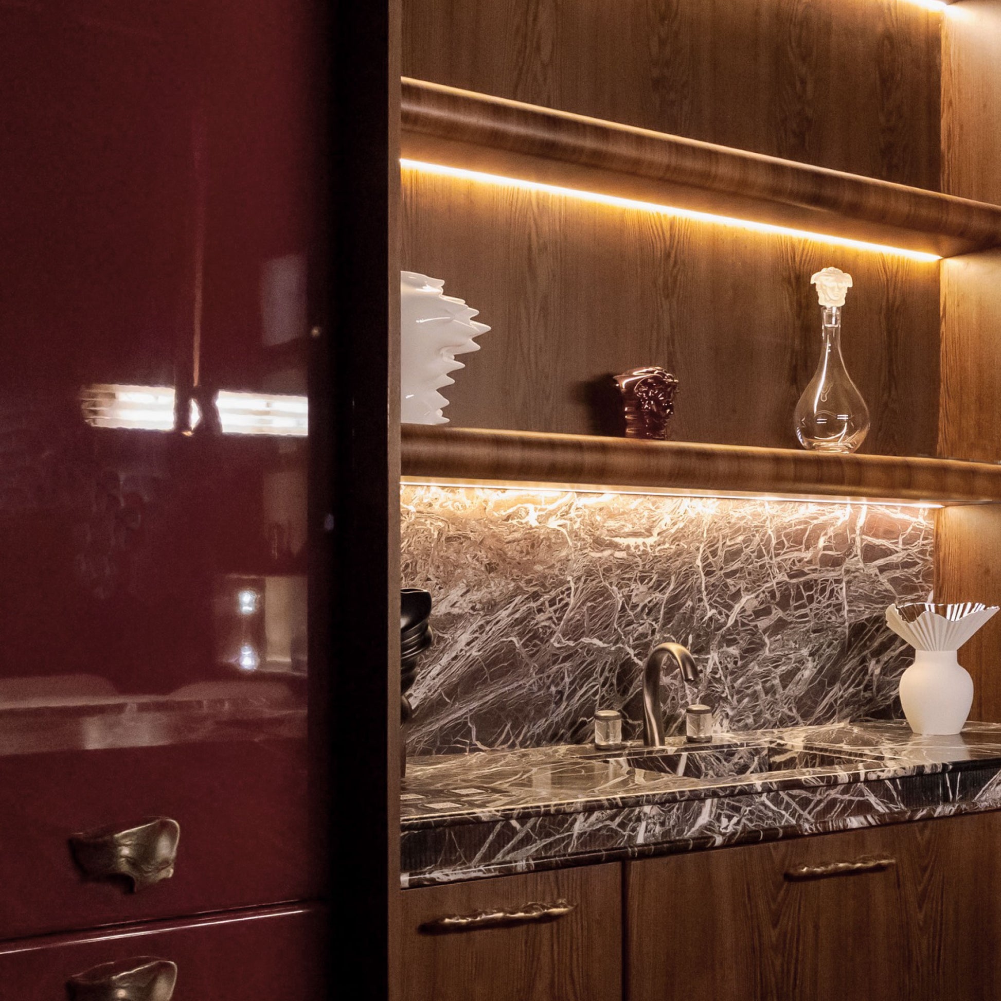Installation view of a wooden cabinet with a organic-patterned handle and brass finish.