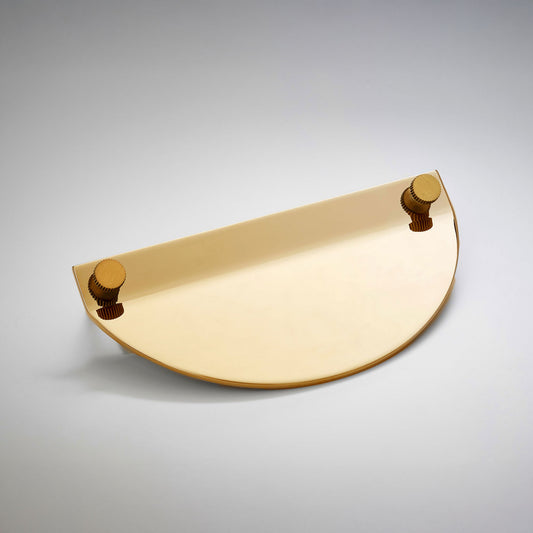 A modern semi-circular cabinet pull in a gold polished brass finish, featuring two small round gold-toned details on the top edges, on a neutral background.