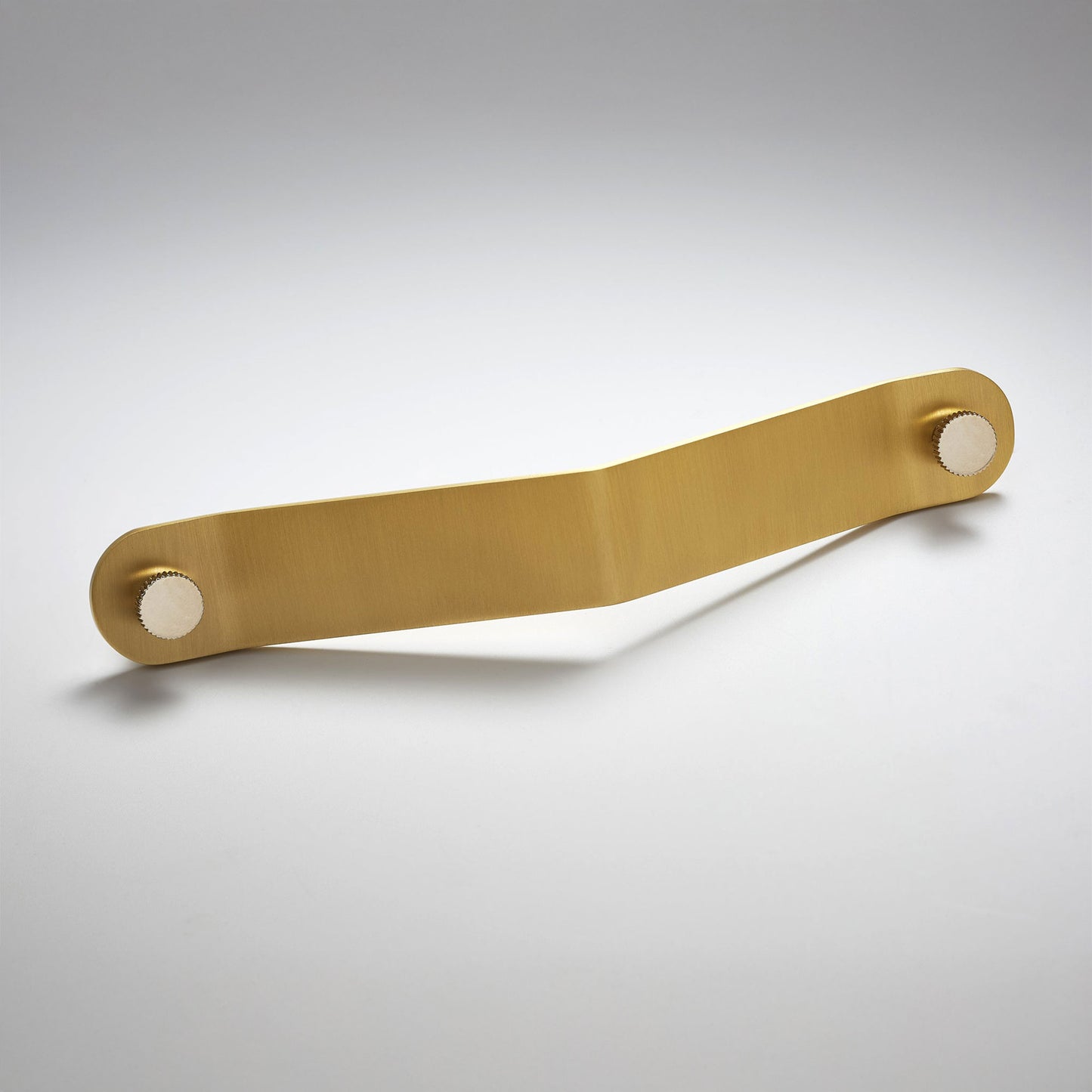 A satin brass metal cabinet pull handle with a rectangular bar and circular mounting bases on both ends, on a light gray background.
