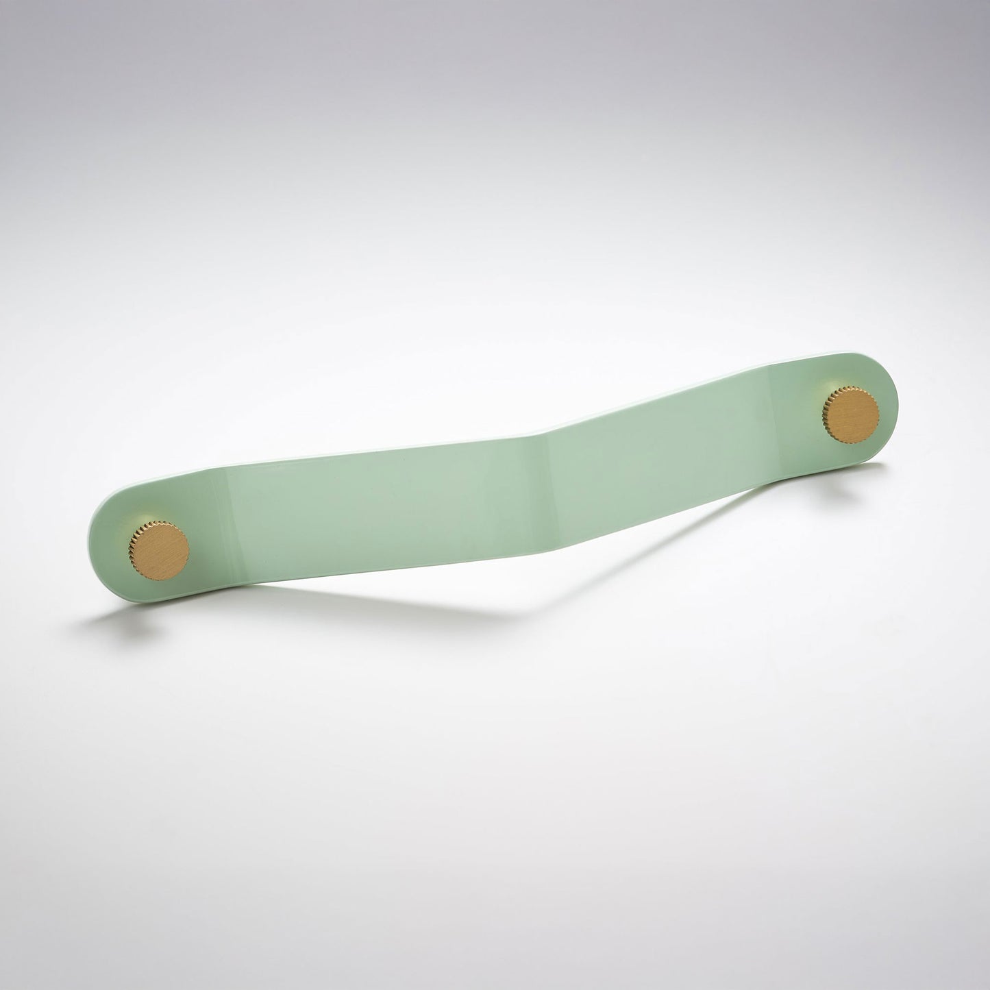 A shiny mint green powder coated, long bent rectangular metal cabinet pull handle with two small, round, brass details on each corner photographed on a white background.