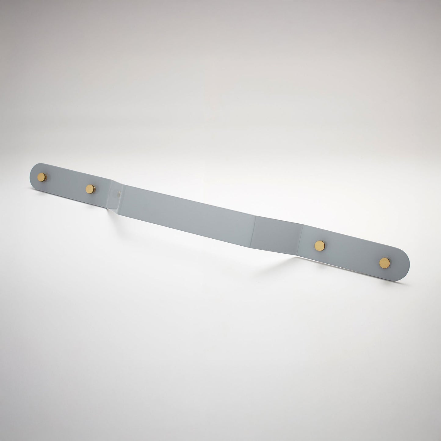 A shiny gray powder coated, extra long bent rectangular metal cabinet pull handle with two small, round, brass details on each corner photographed on a white background.