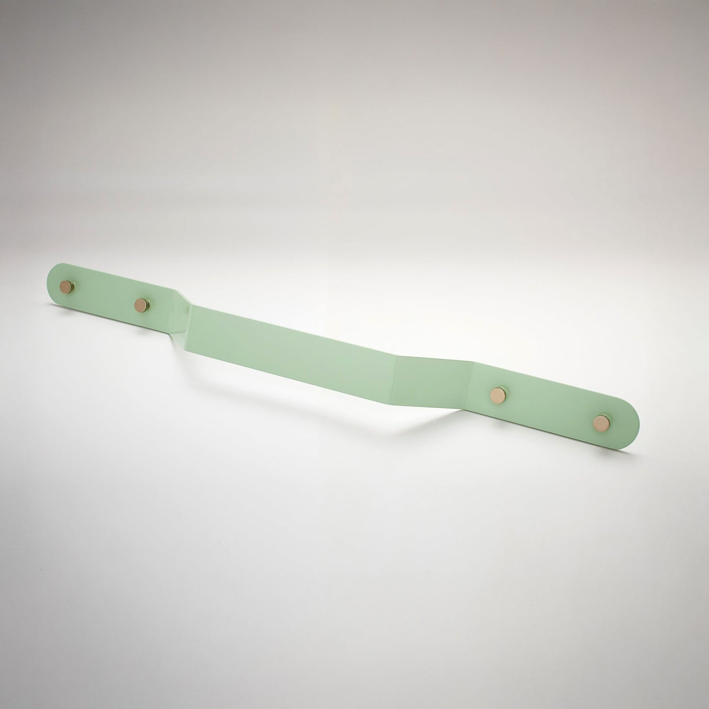 A shiny mint green powder coated, extra long bent rectangular metal cabinet pull handle with two small, round, brass details on each corner photographed on a white background.