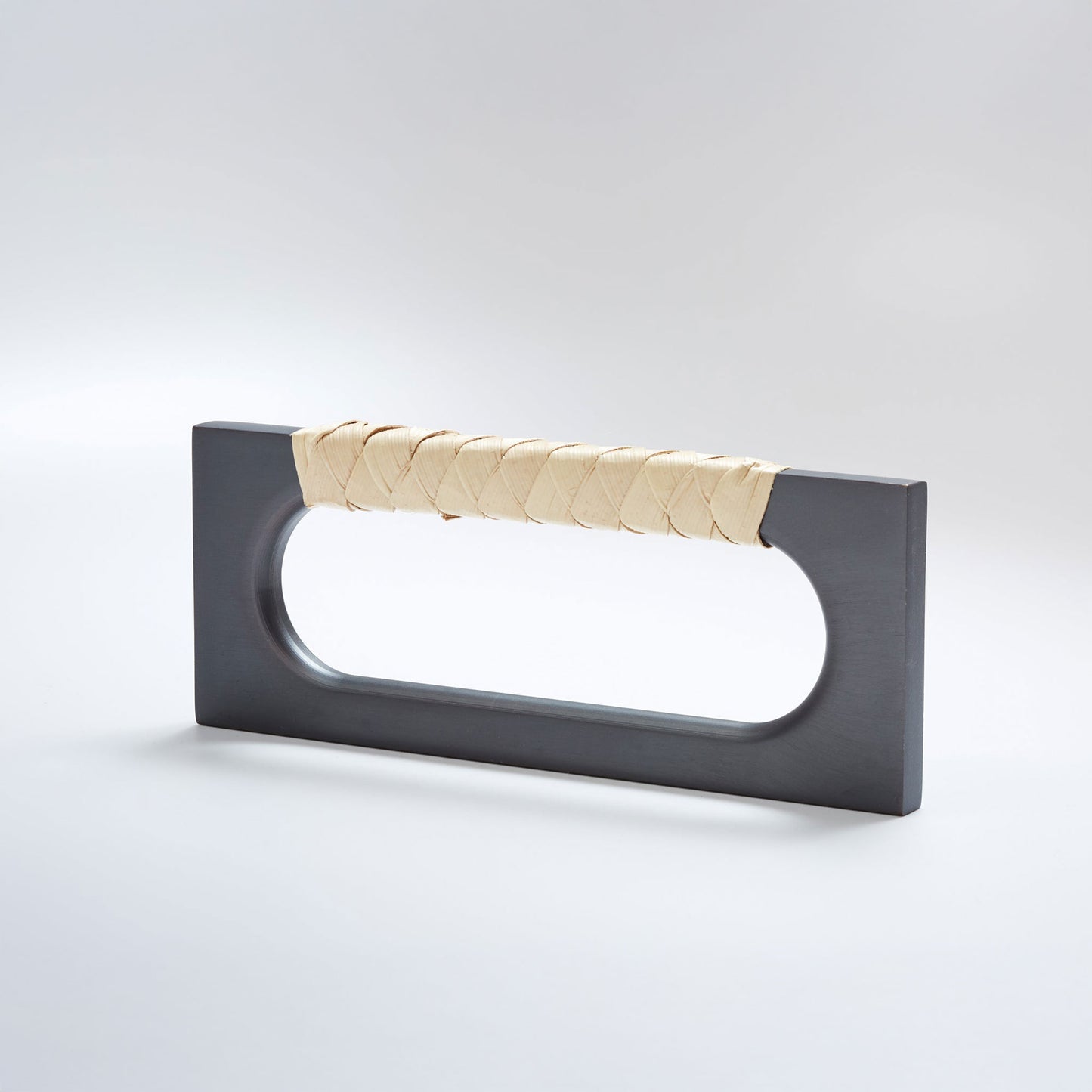 A modern rectangular cabinet pull handle with a dark oil-rubbed bronze finish and a textured woven light tan leather handle, shown on a white background.