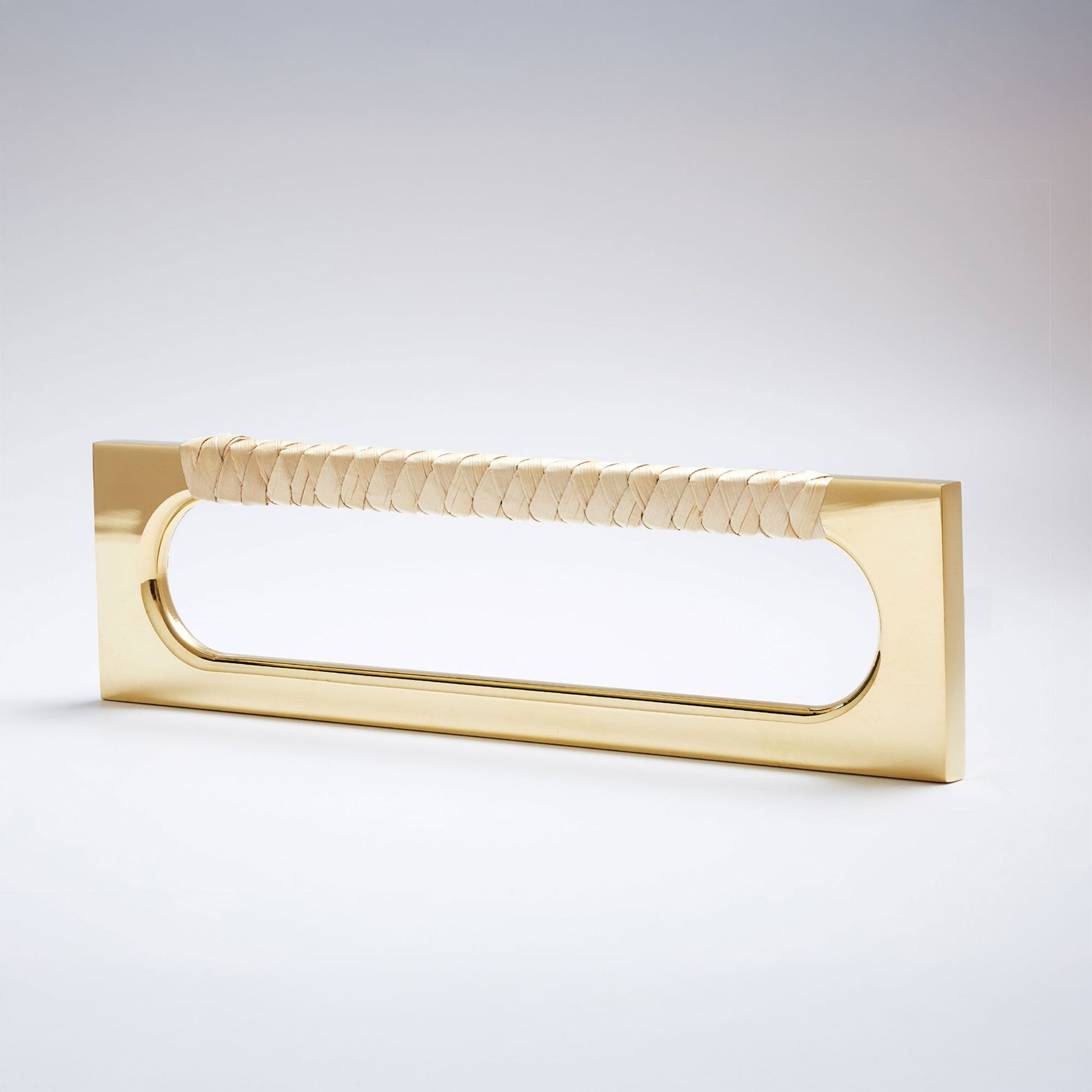 A modern long rectangular cabinet pull handle featuring a polished brass metal frame and a textured light natural tan braided pine grip, shown on a white background.