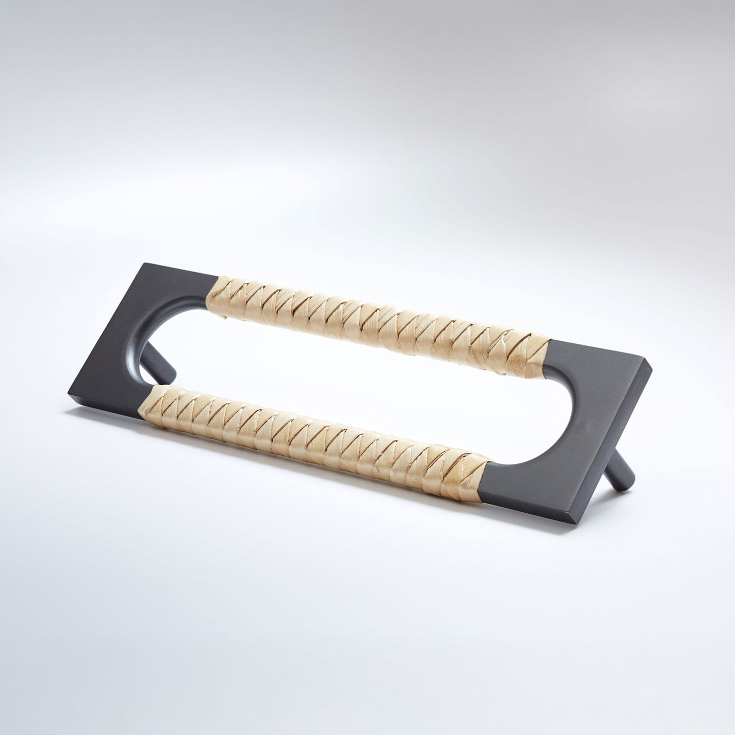 A modern black metal pull handle with two wrapped natural fiber grips, shown on a clean light gray background.