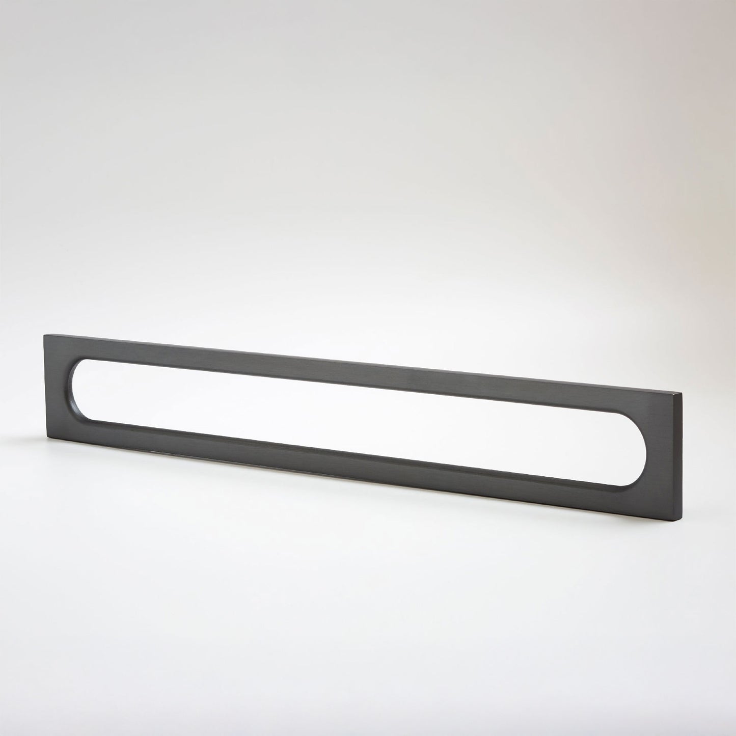 A long, narrow rectangular metak cabinet pull with a rounded rectangular cutout in the center, photographed on a clean light gray studio background.