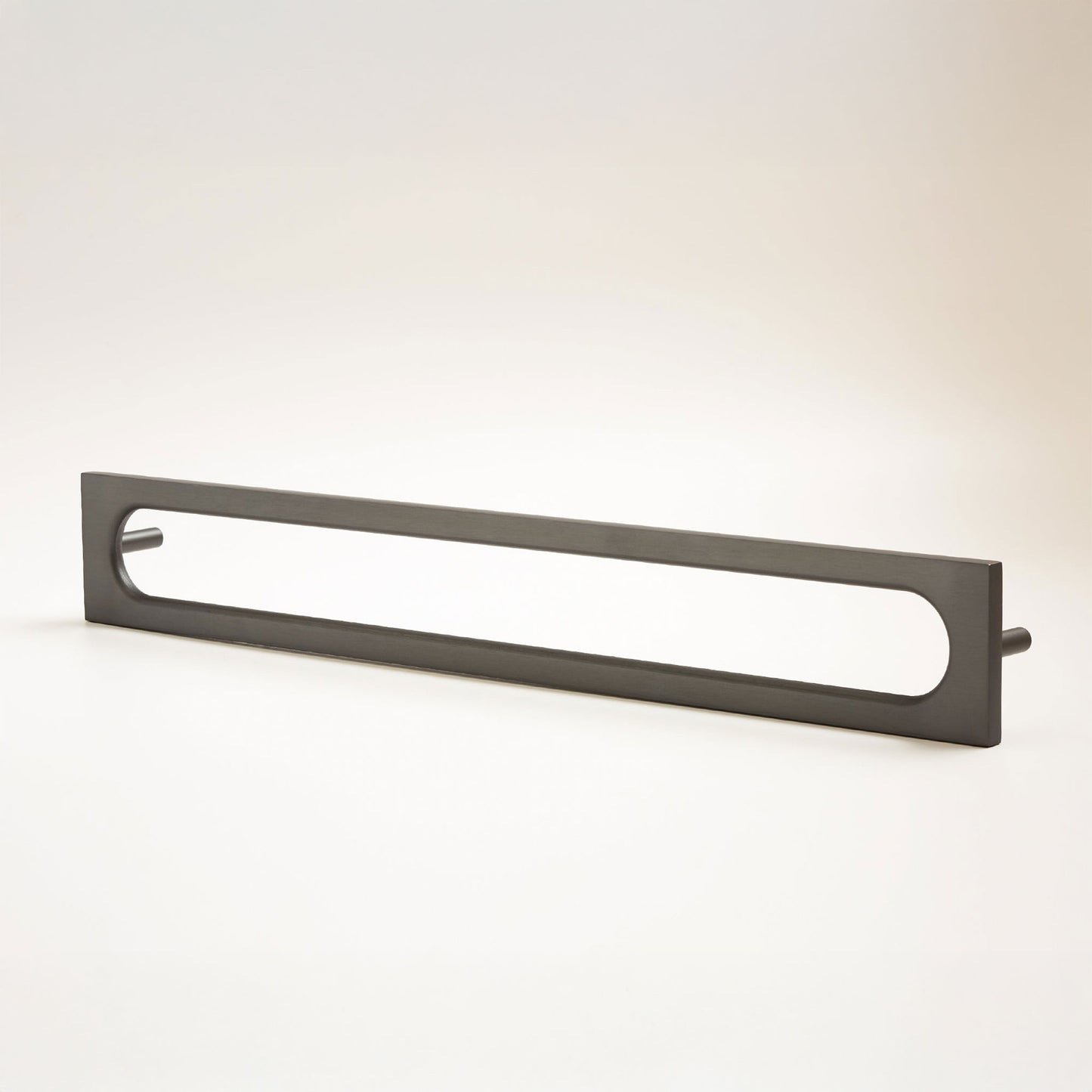 A long, narrow rectangular metal cabinet pull with a rounded rectangular cutout in the center, photographed on a clean light gray studio background.