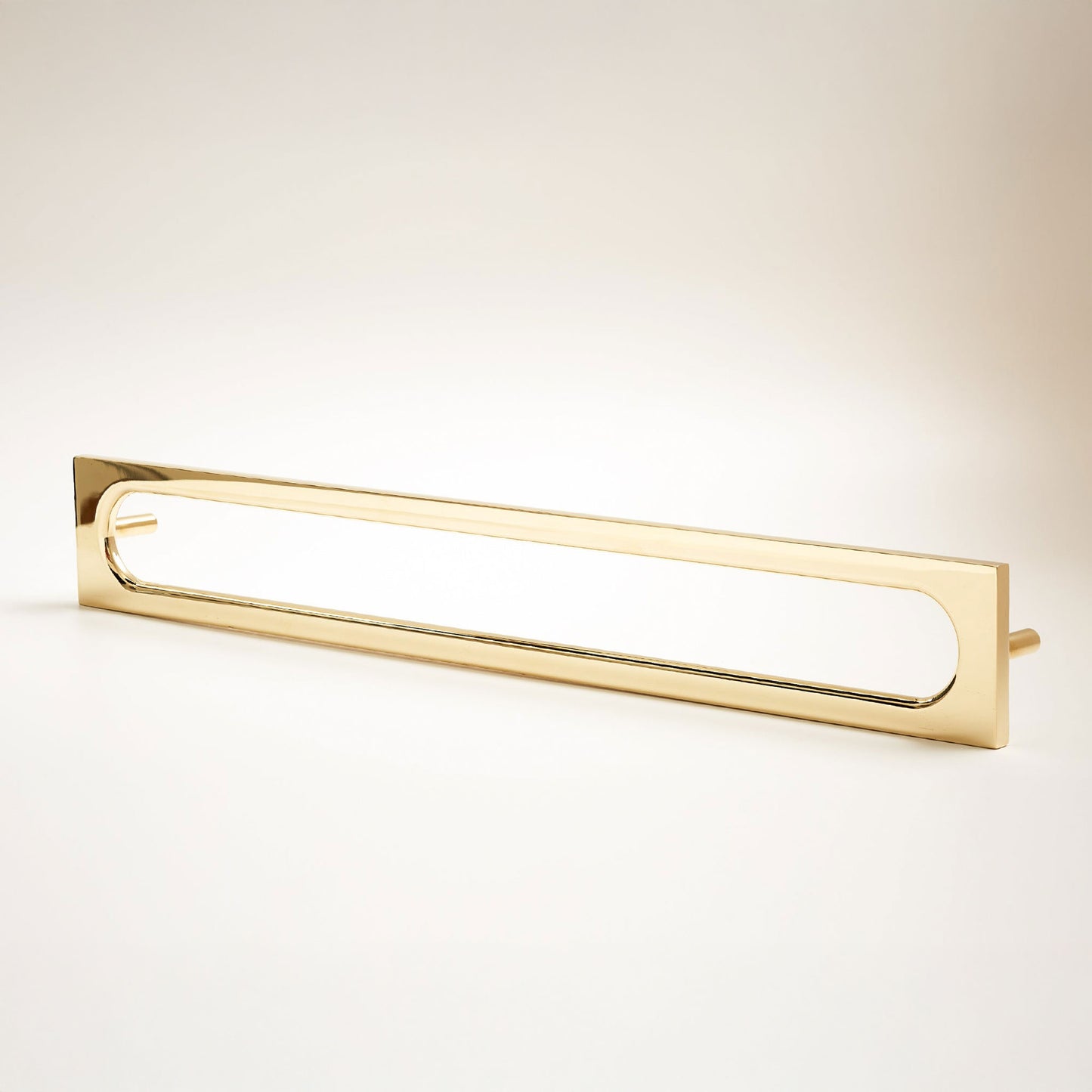 A long, narrow rectangular metal cabinet pull with a rounded rectangular cutout in the center, photographed on a clean light gray studio background.