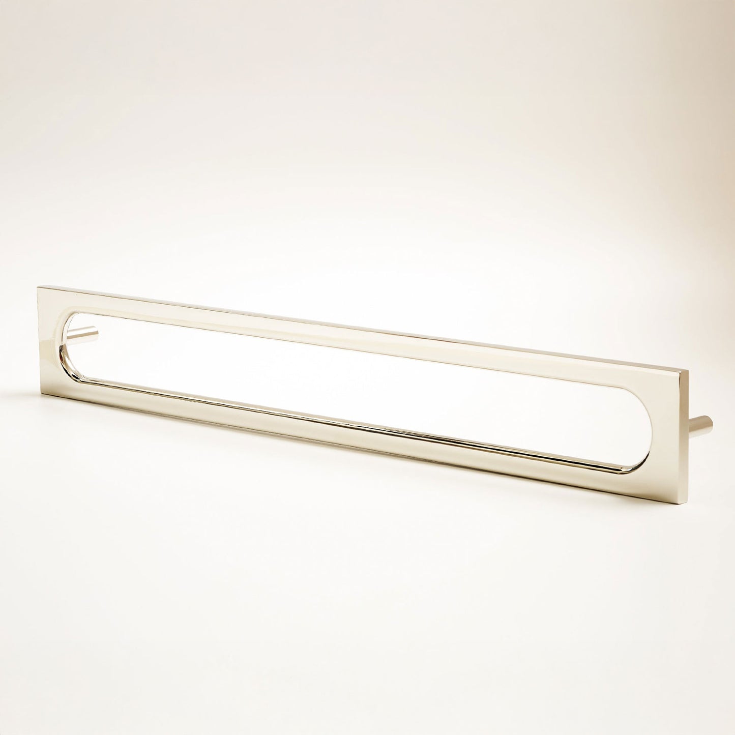 A long, narrow rectangular metal cabinet pull with a rounded rectangular cutout in the center, photographed on a clean light gray studio background.