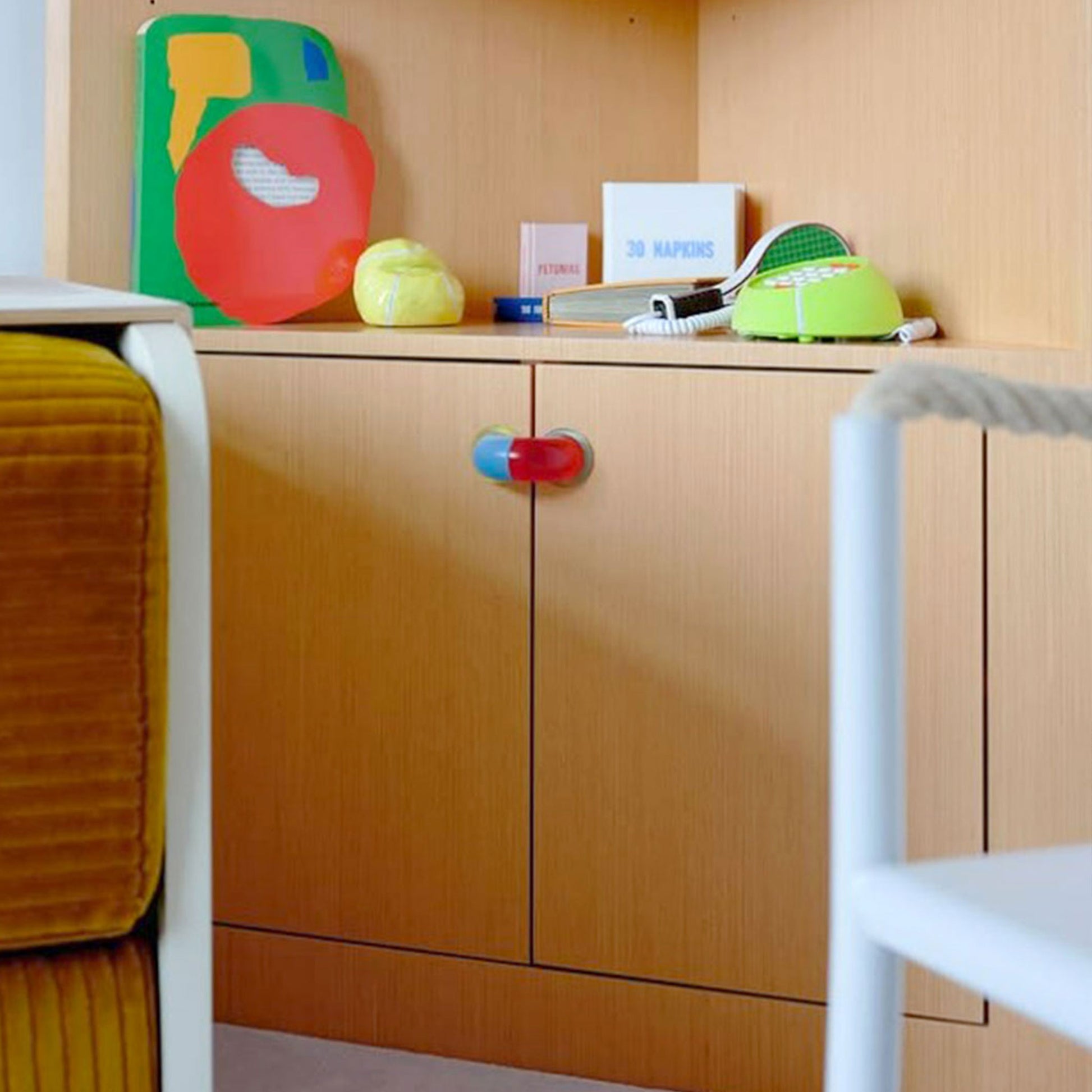 bicolored red and blue arch shaped hardware on a wood cabinet door pair