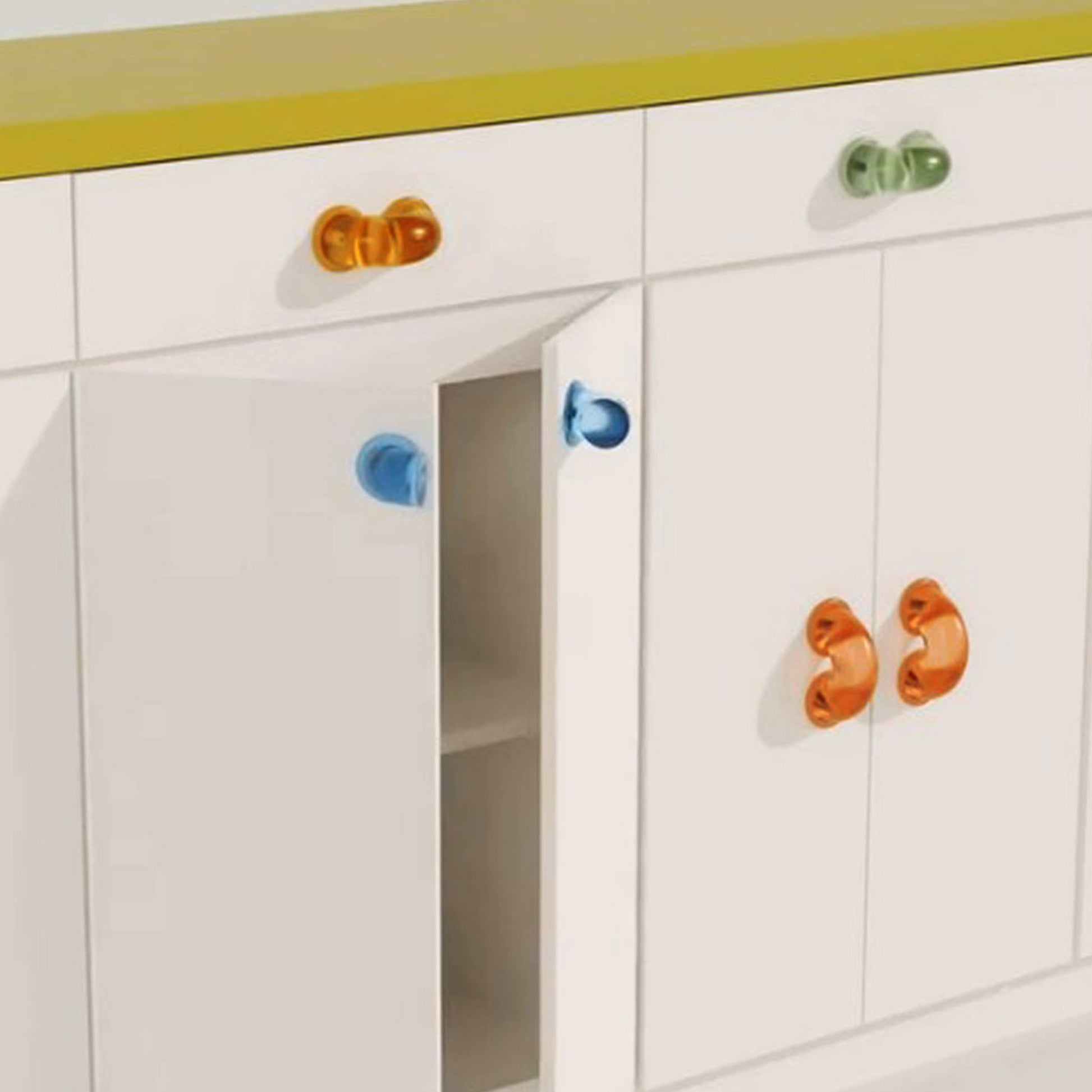 chunky colorful arch shaped hardware on white cabinetry