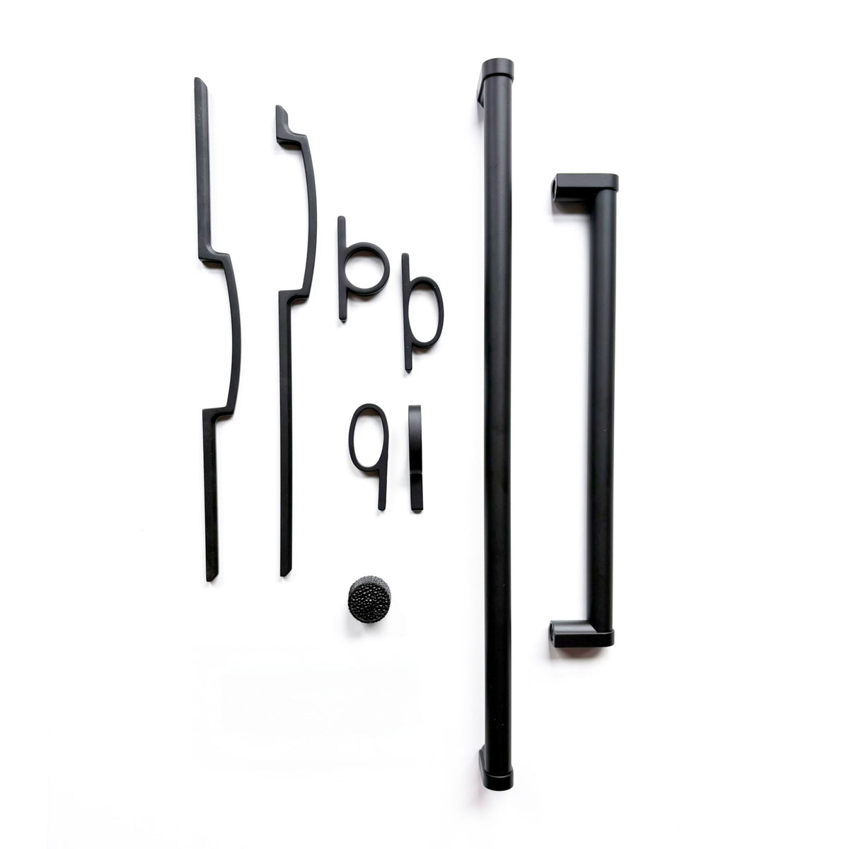 a grouping of various cabinet and appliance pulls in a matte black finish on a solid white background
