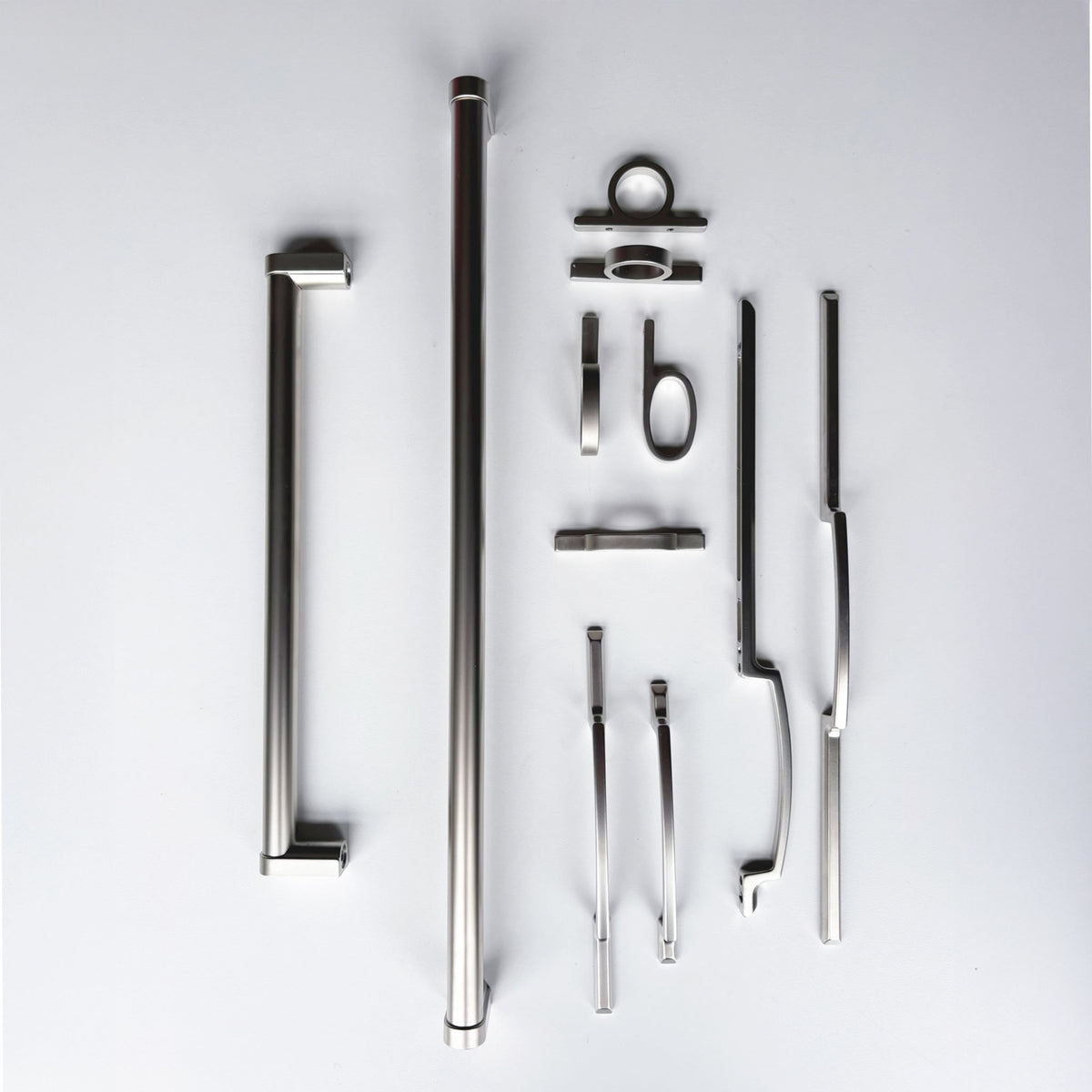 a grouping of various cabinet and appliance pulls in a matte nickel finish  on a solid white background