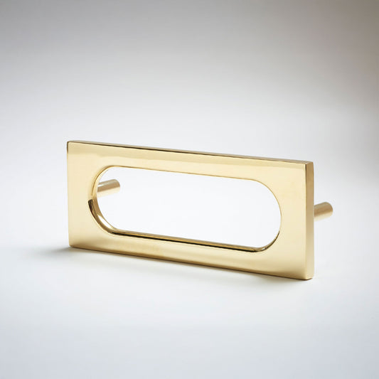 A polished brass rectangular drawer pull with an elongated oval cutout, shown on a clean light gray background.