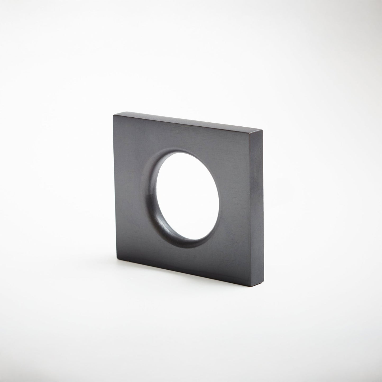 A modern square metal cabinet pull with a circular cutout in the center, shown on a clean light gray background.