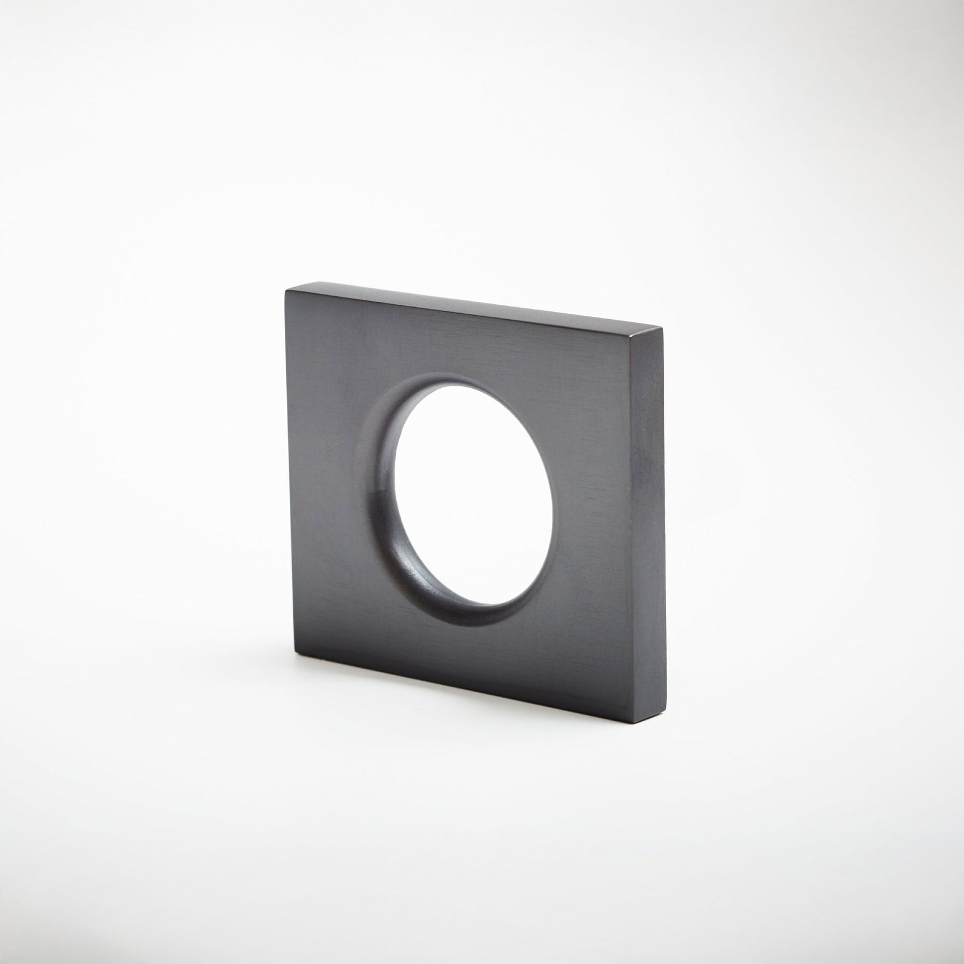 A modern square metal cabinet pull with a circular cutout in the center, shown on a clean light gray background.
