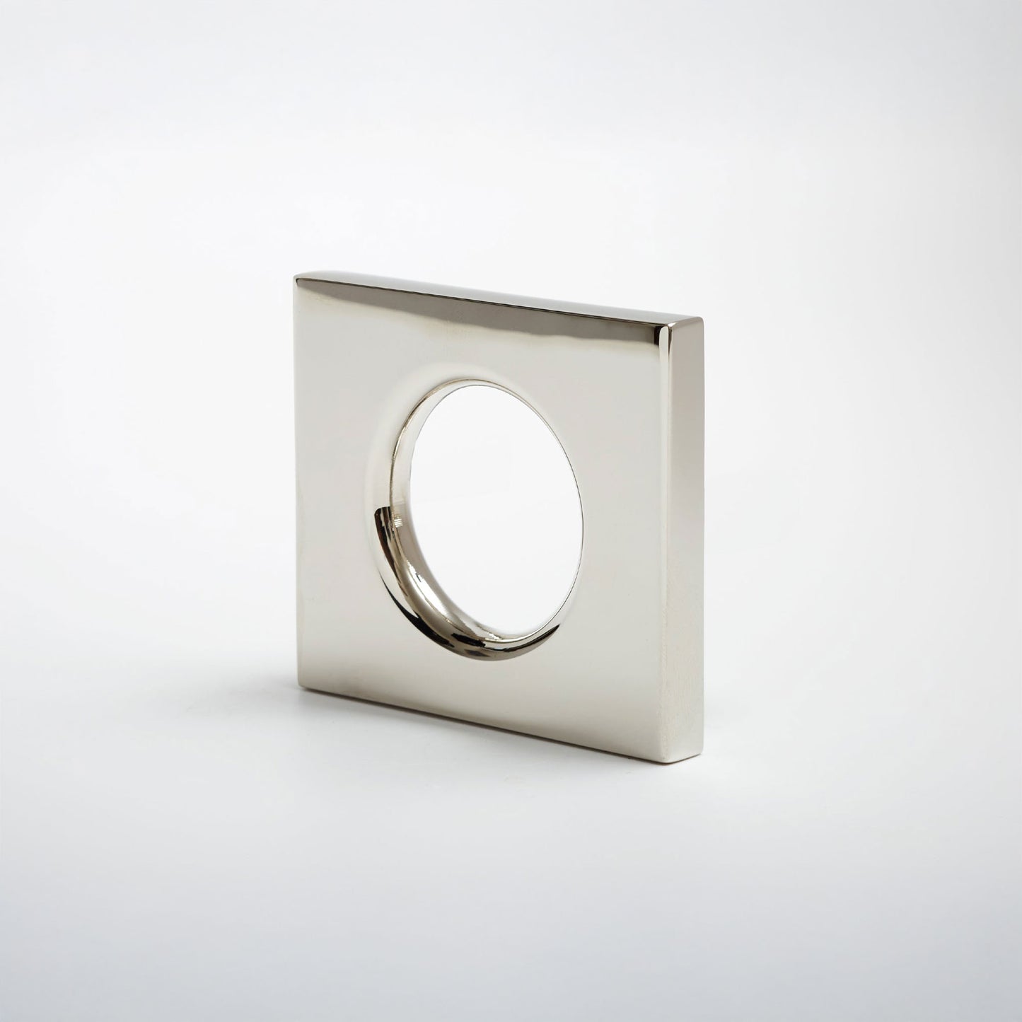 A modern square metal cabinet pull with a circular cutout in the center, shown on a clean light gray background.