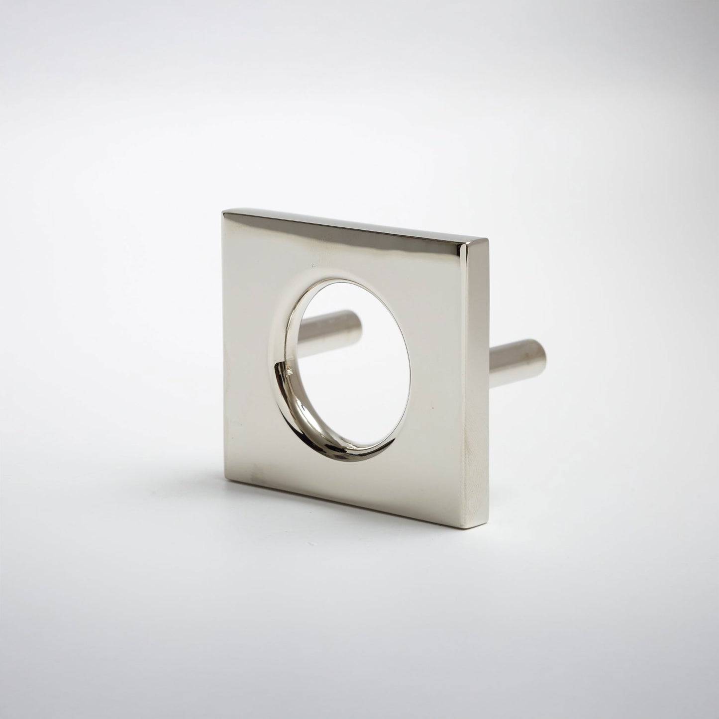 A modern square metal cabinet pull with a circular cutout in the center, shown on a clean light gray background.
