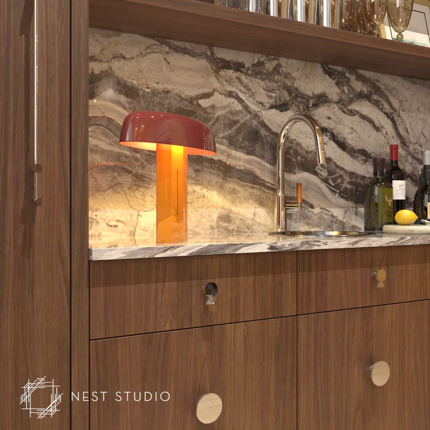 A modern kitchen cabinet scene with a warm amber table lamp on a marble countertop, a curved faucet, marble backsplash, and wood cabinetry. A Nest Studio watermark appears in the lower left corner.