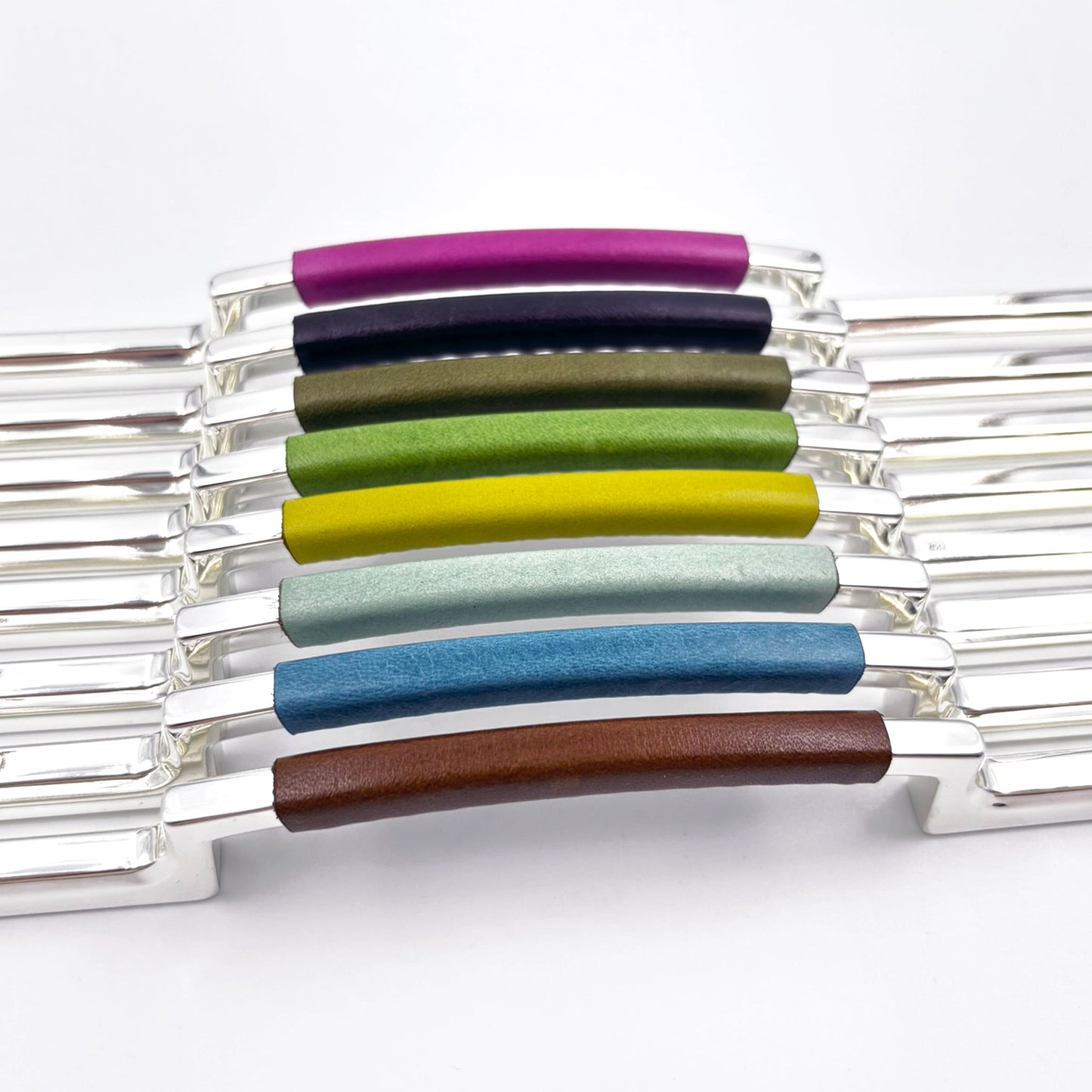 metal cabinet pulls with colorful leather handles on a white background