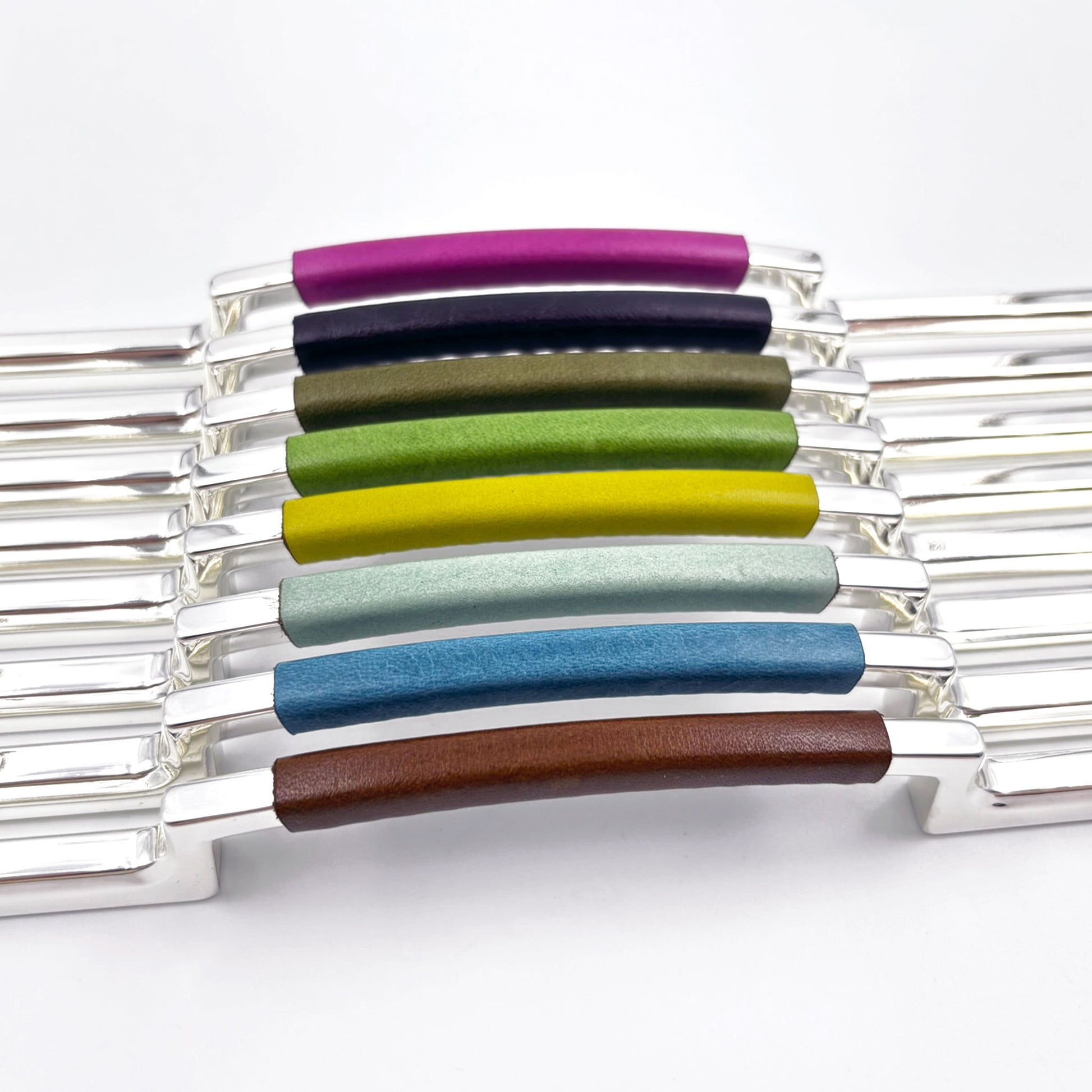 metal cabinet pulls with colorful leather handles on a white background