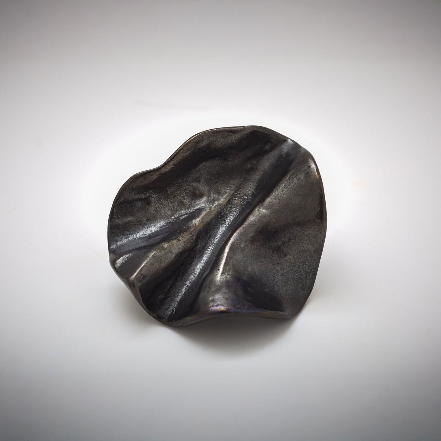 Organic Pinch pleated shped cabinet knob photographed on a grey background