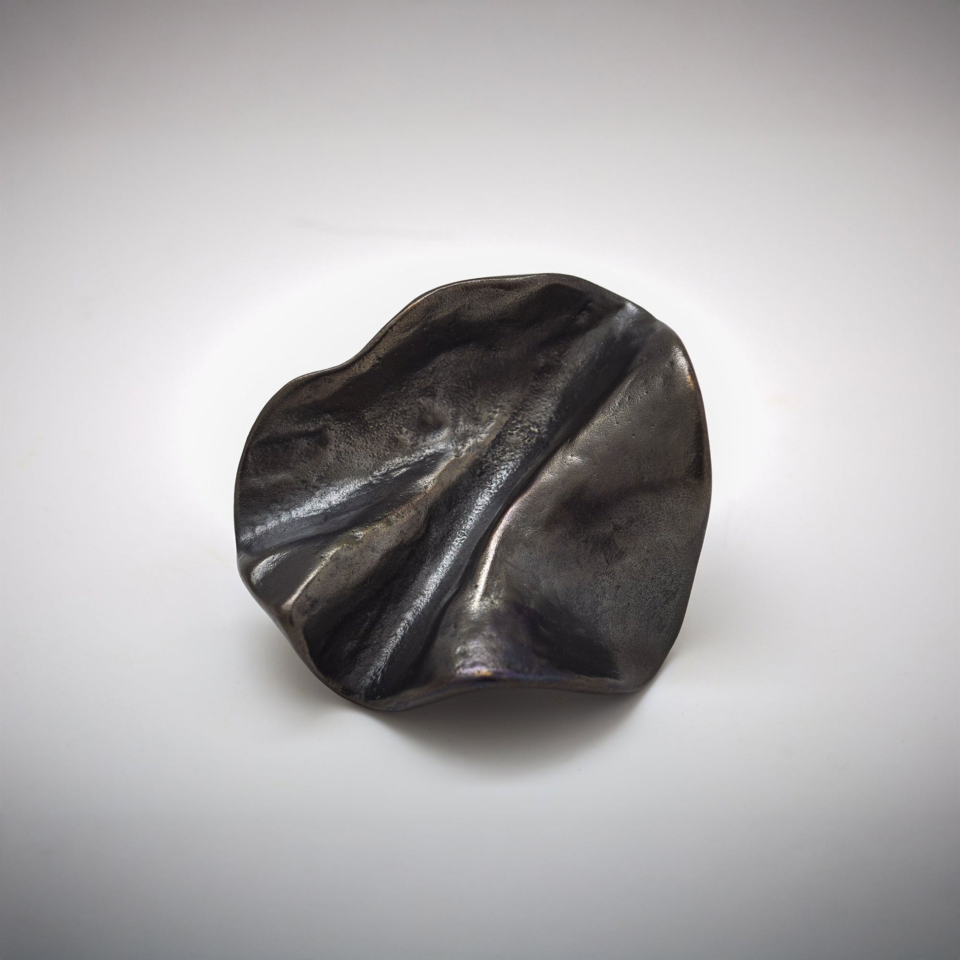 Organic Pinch pleated shped cabinet knob photographed on a grey background