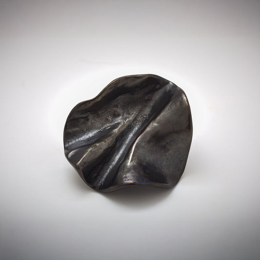 Organic Pinch pleated shped cabinet knob photographed on a grey background
