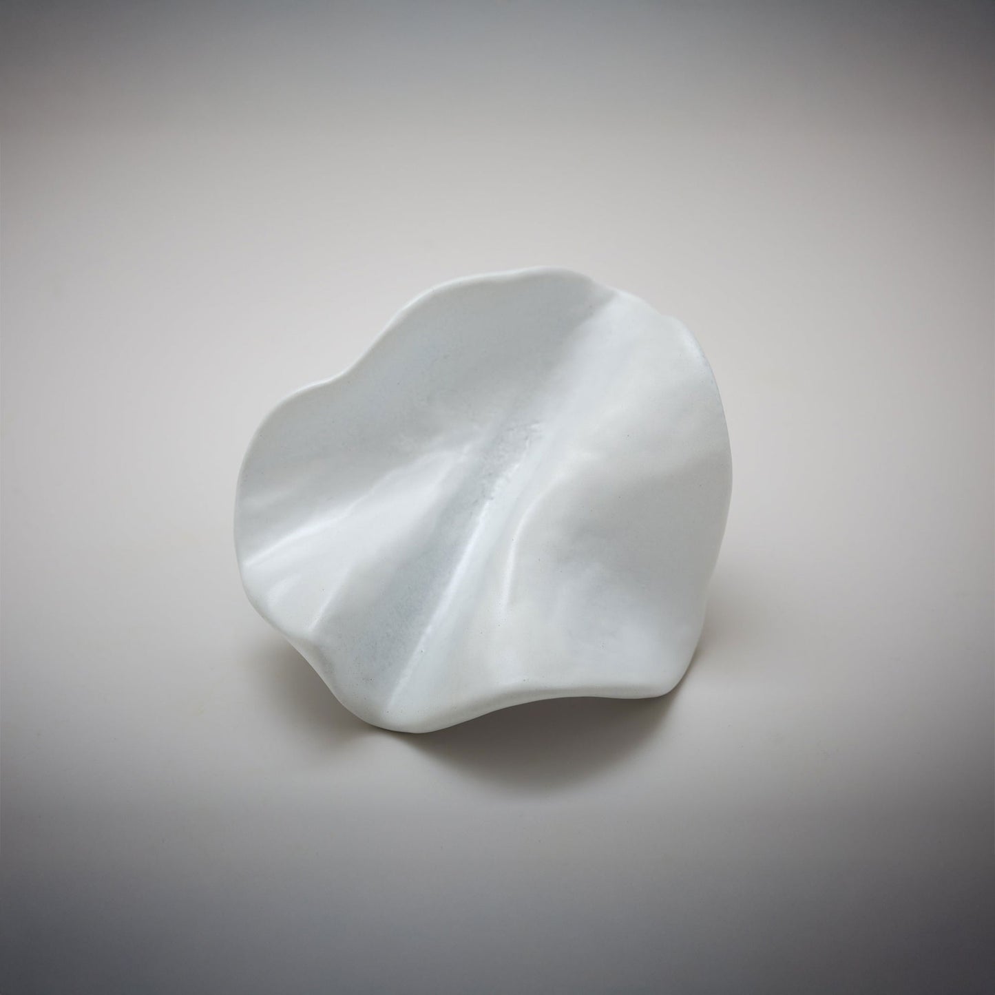 Organic Pinch pleated shped cabinet knob photographed on a grey background