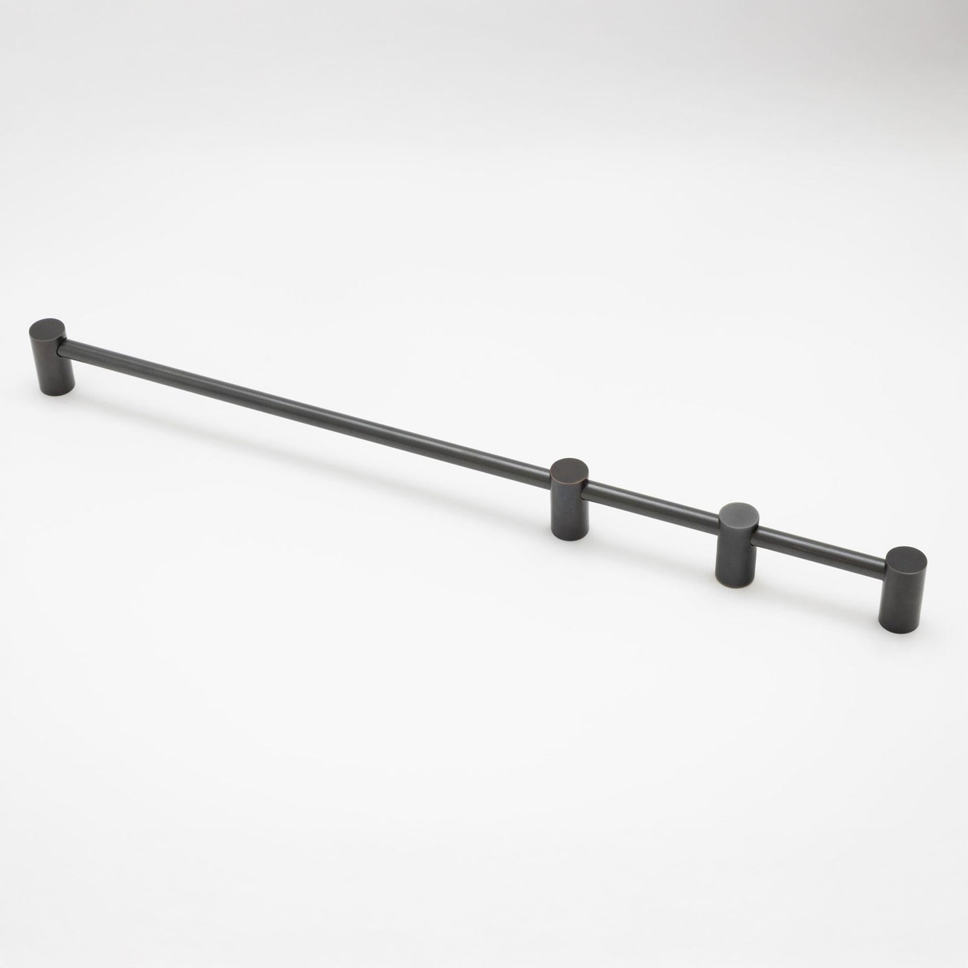 A matte black metal cabinet pull with cylindrical end caps and three mounting posts, shown on a clean white background.