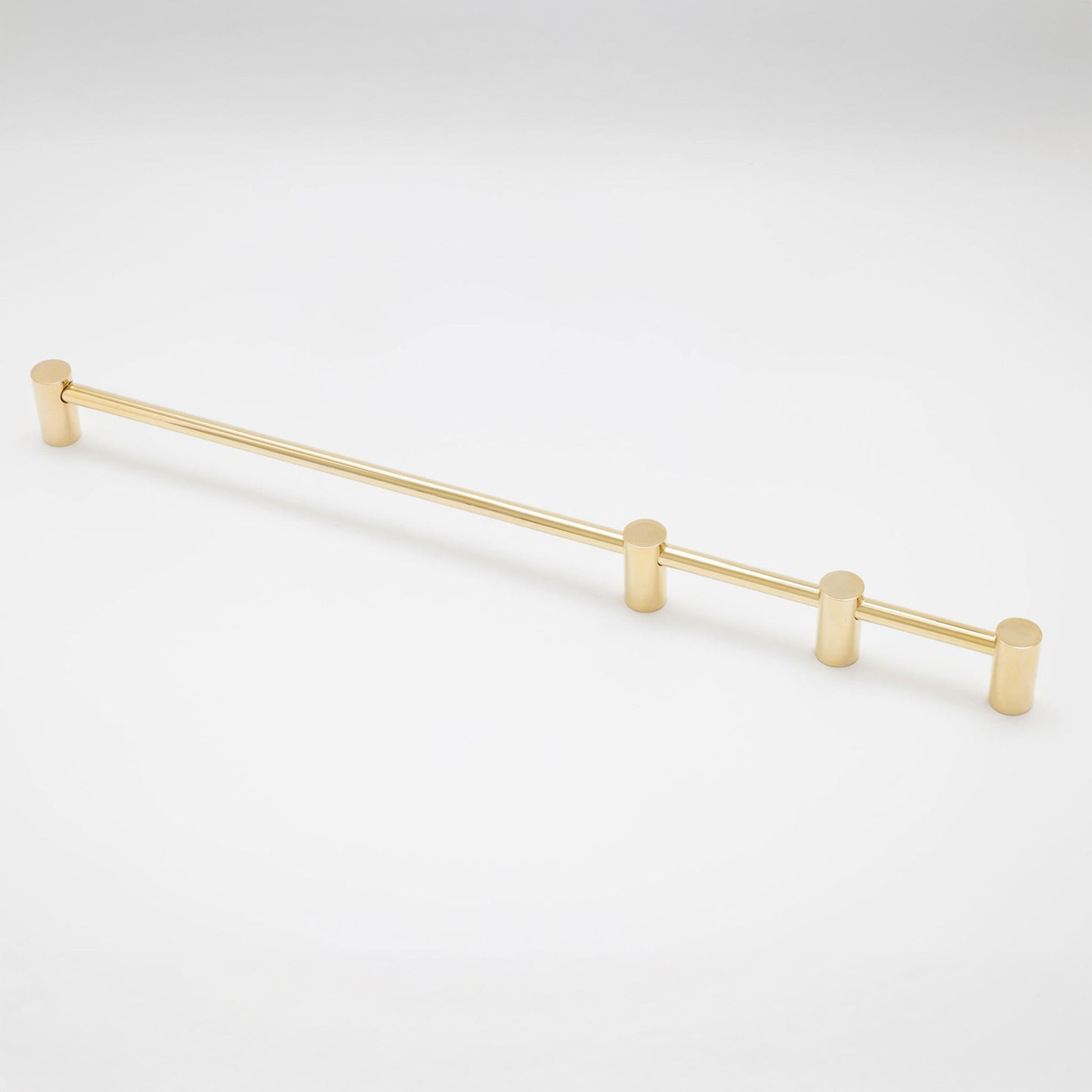 A slim, brushed gold metal cabinet pull handle with a straight bar and three cylindrical mounting posts, shown on a clean white background.