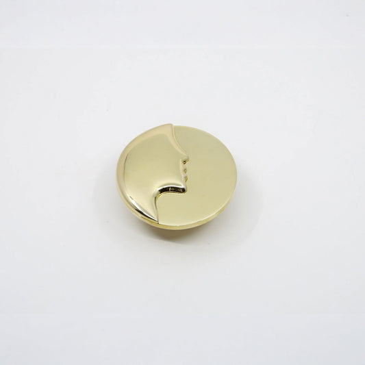 A single round, polished gold cabinet knob with a small cutout detail, shown on a plain white background.