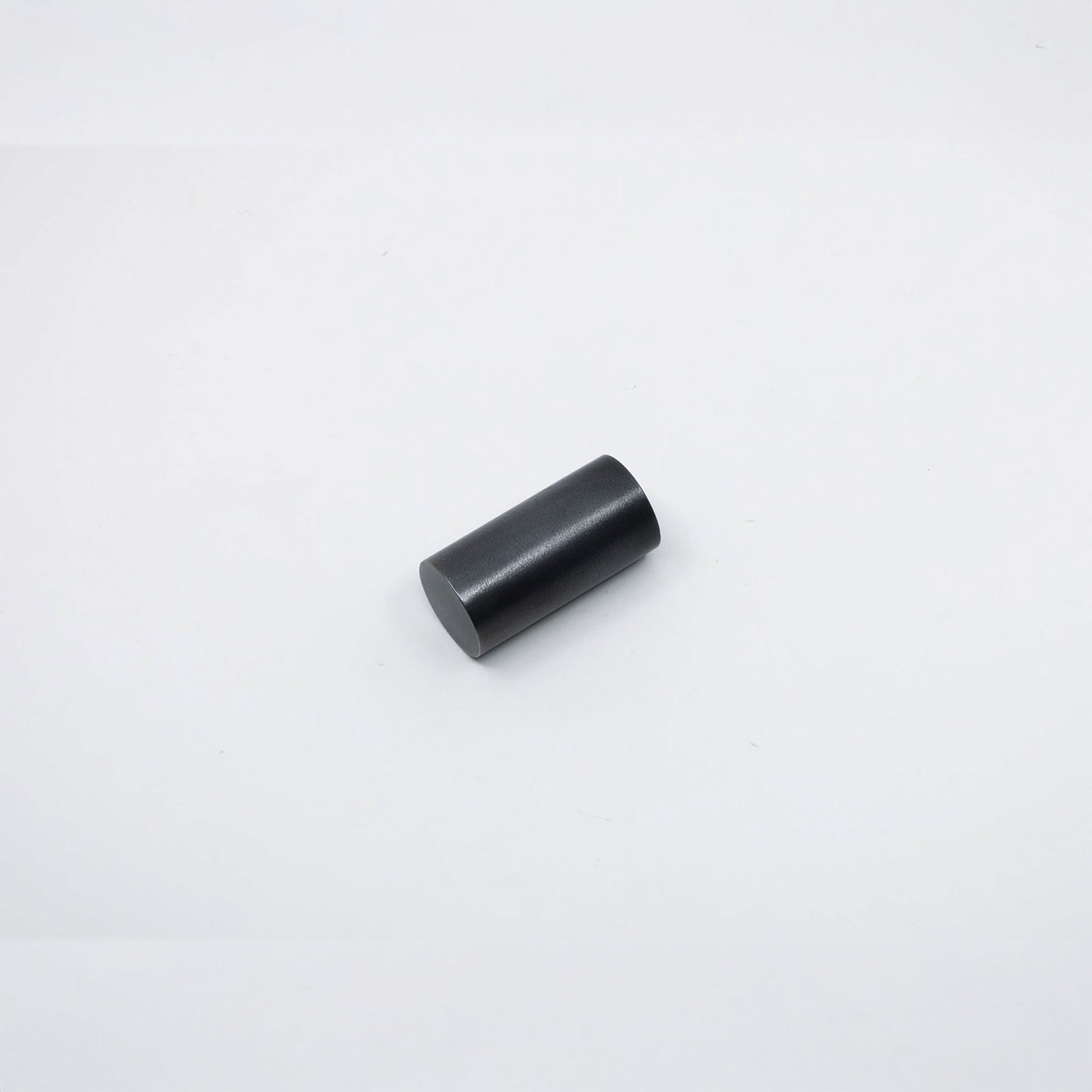 A small black cylindrical metal knob, shown on a plain white background.