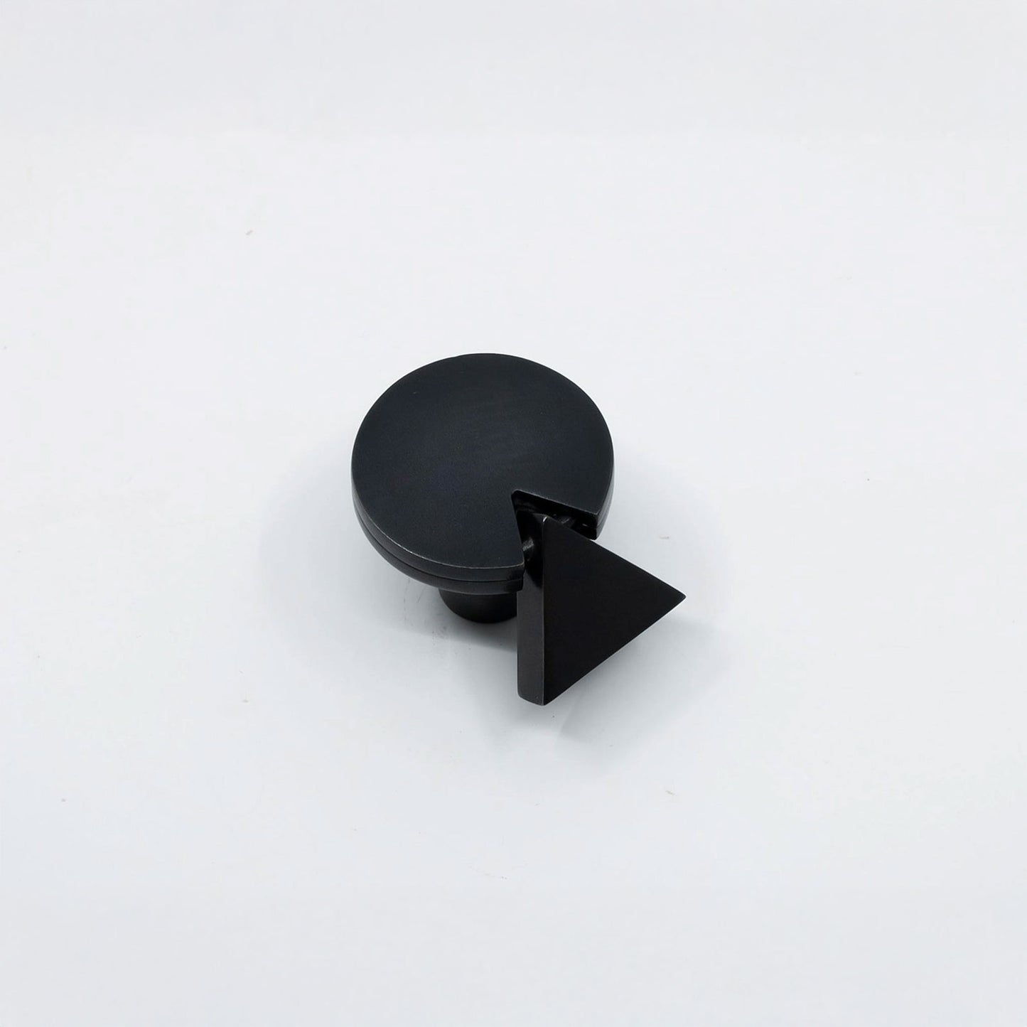 A matte black cabinet knob with a circular top and a triangular pull handle, shown on a clean white background.