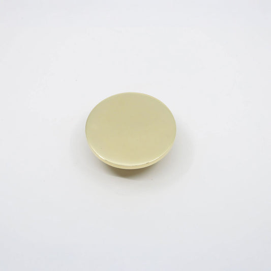 A small, round, flat disc cabinet knob with a smooth, matte pale yellow surface, photographed from directly above on a clean white background.