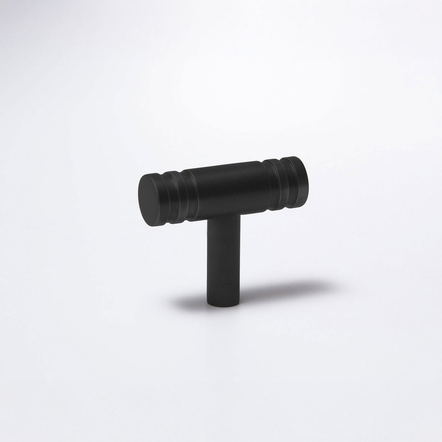 A matte black T-shaped cabinet knob with a cylindrical handle and a straight stem, shown on a clean white background.